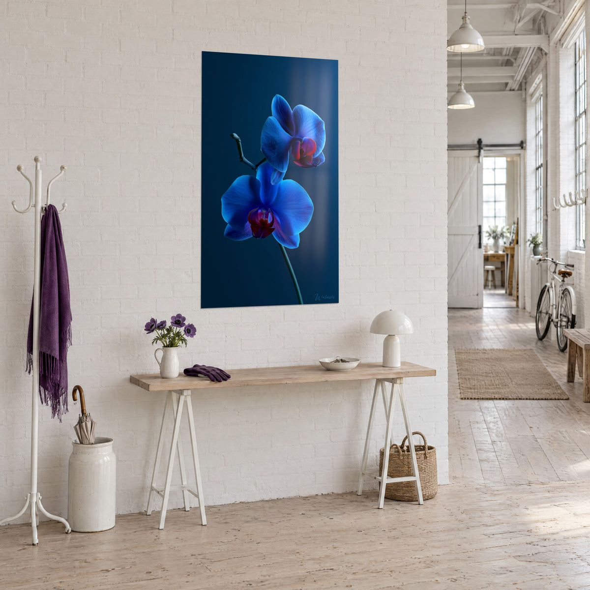 Quadro phalaenopsis indaco e porpora su fondo blu marino, appeso accanto a una consolle in legno chiaro in un loft d'artista
