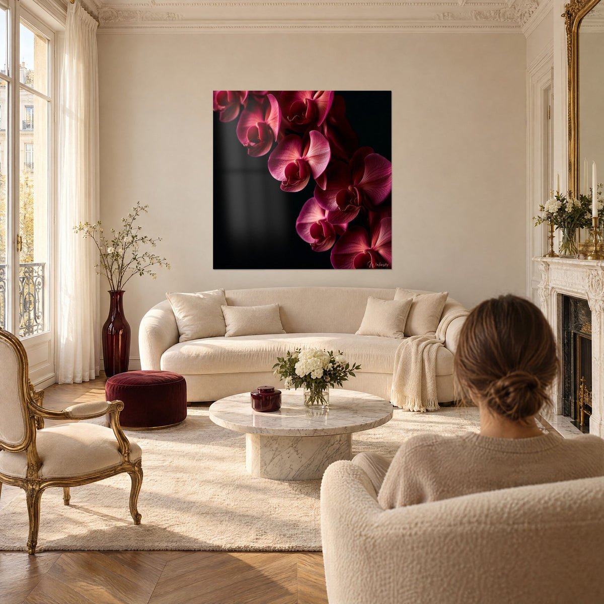 Wall art with cascading pink orchids, powder-pink petals and burgundy hearts on a black background, above a sofa in a bright living room