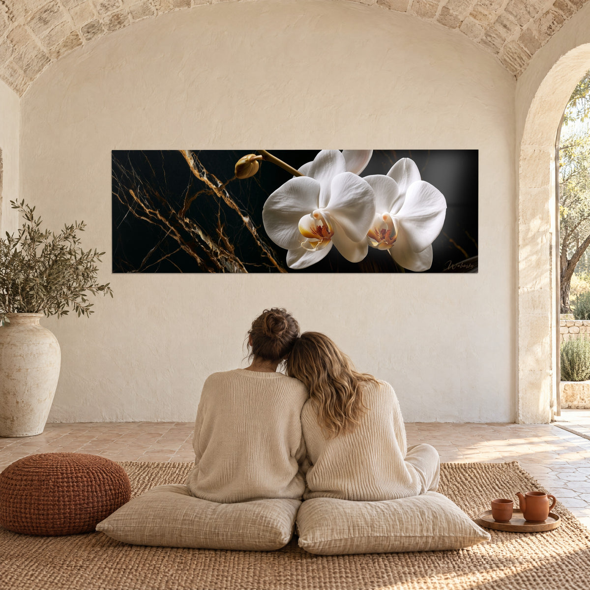 Quadro orchidea bianca immacolata su marmo nero venato di rame dorato, sotto una volta di pietra, coppia di spalle sui cuscini
