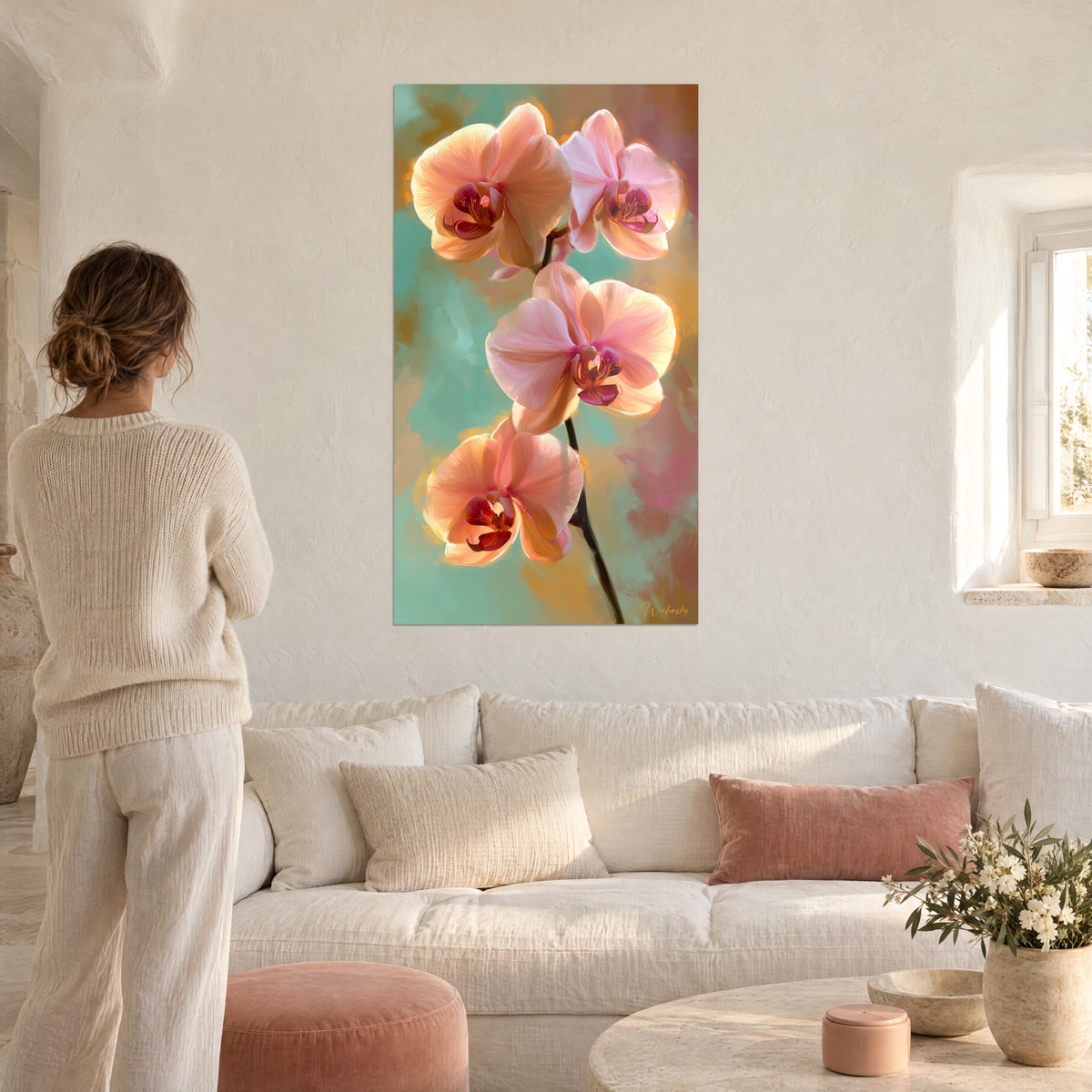 Cuadro orquídeas melocotón en cascada sobre fondo verde agua y rosa polvoso, mujer de espaldas sobre un sofá en un salón luminoso