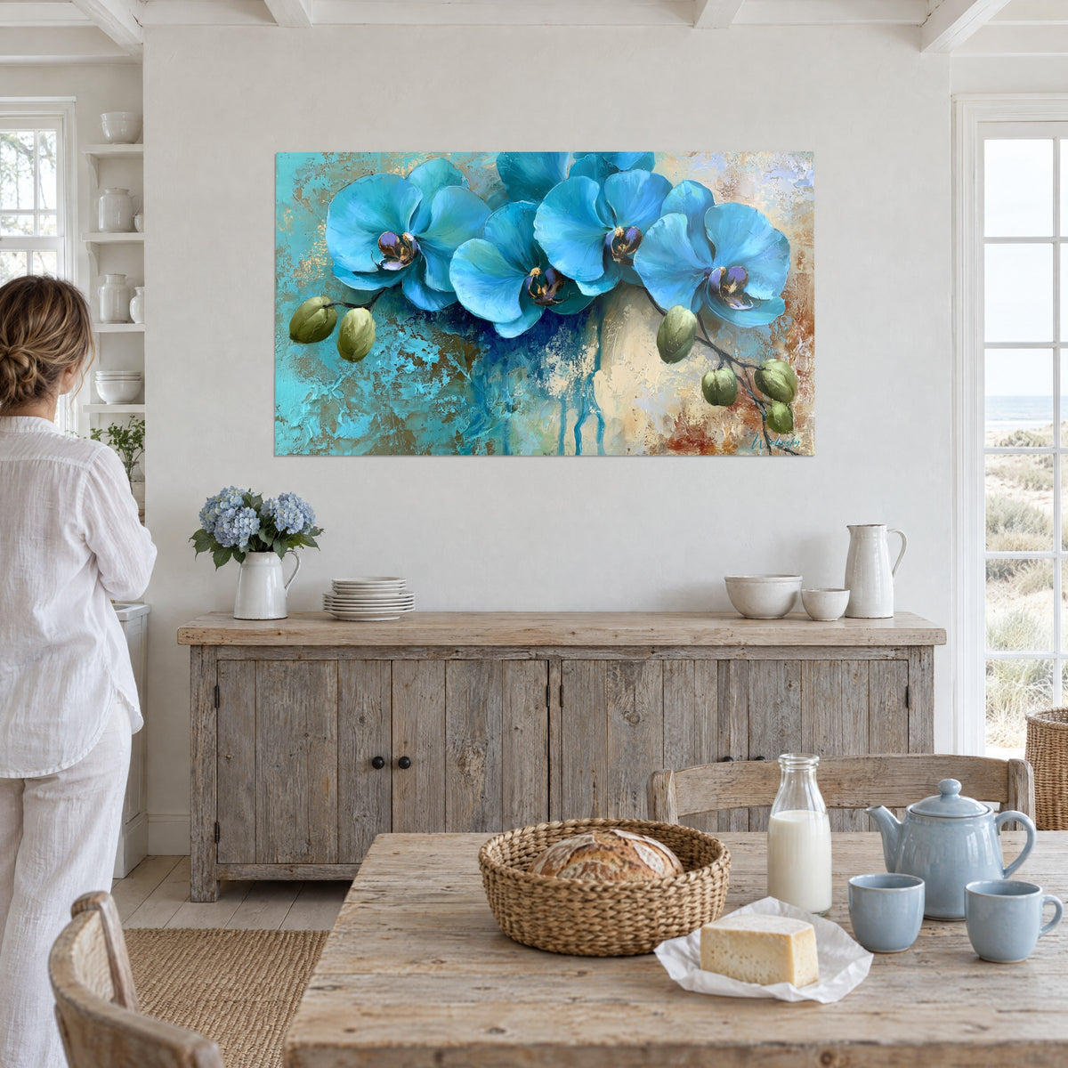 Schilderij cyaanblauwe orchideebloemen met indigo druipsporen op crème achtergrond, vrouw in het wit met de rug naar de kijker, eetkamer aan zee