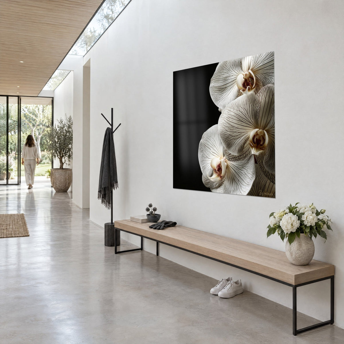Wall art three cream orchid blooms with burgundy hearts on ink-black background, hung in a light concrete hallway