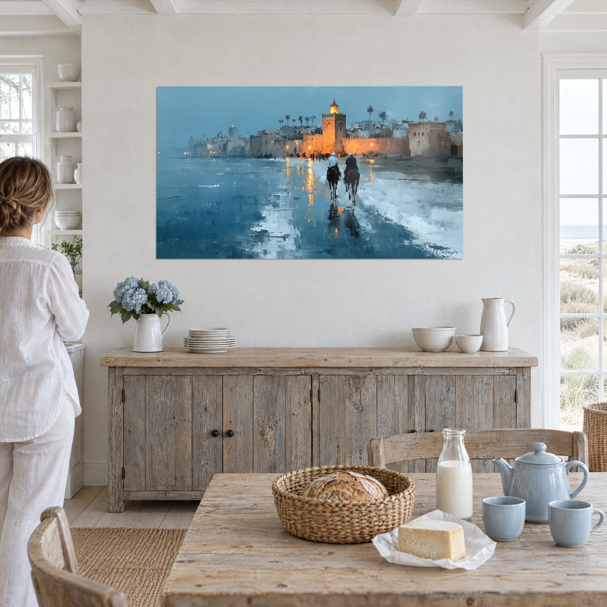 Quadro città ocra illuminata sul bordo della laguna, riflessi ramati nell'acqua blu, sala da pranzo bianca sul mare