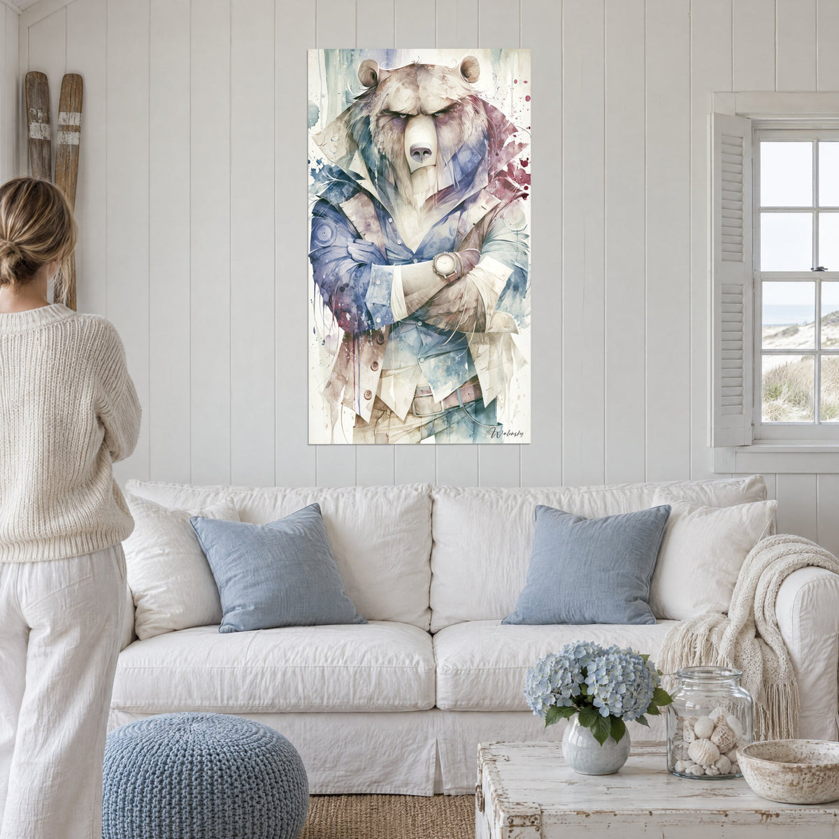 Gemälde Brauner Bär mit strengem Blick, marineblaue und beige Jacke, verschränkte Arme, bordeauxrote Spritzer, über einem Sofa in einem hellen Wohnzimmer