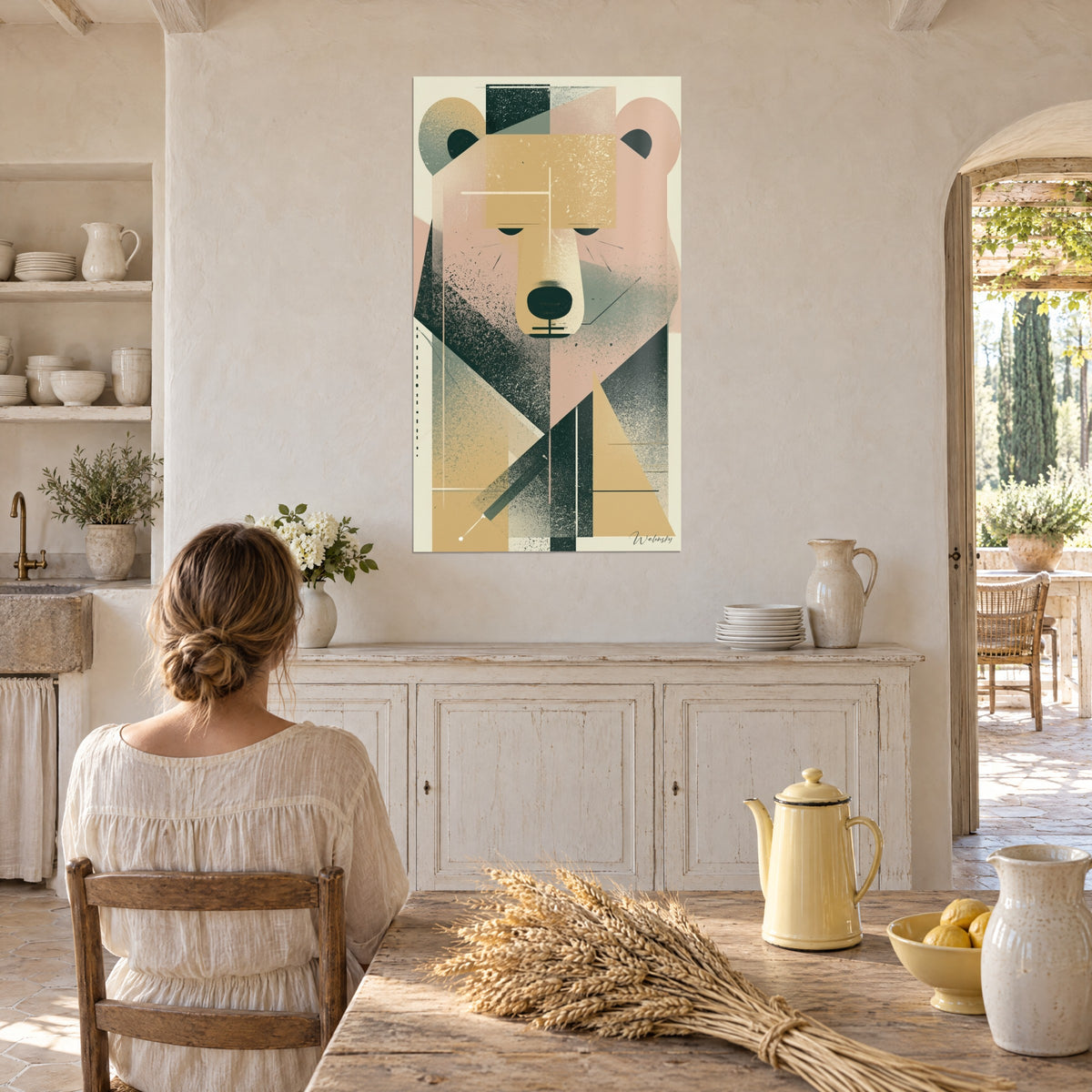 Tableau grand ours aux paupières closes, rose pâle, ocre doré et triangle crème, face à une femme attablée dans la cuisine du mas