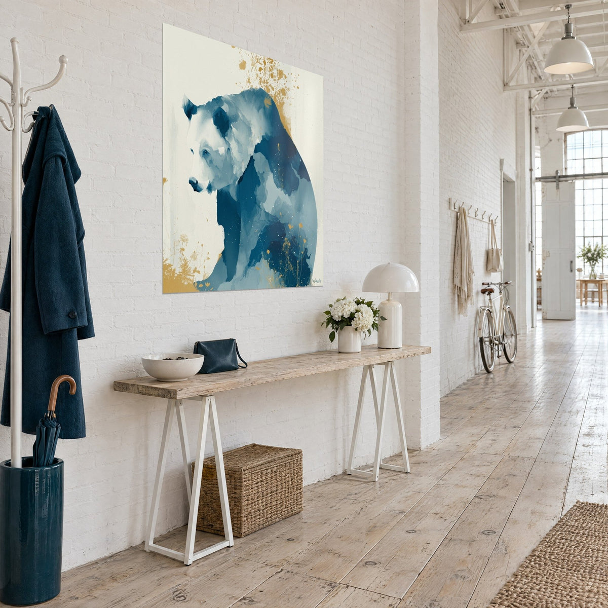 Quadro sagoma d'orso in lavis blu notte e bianco crema, punte dorate, parete bianca di un loft, console in legno chiaro