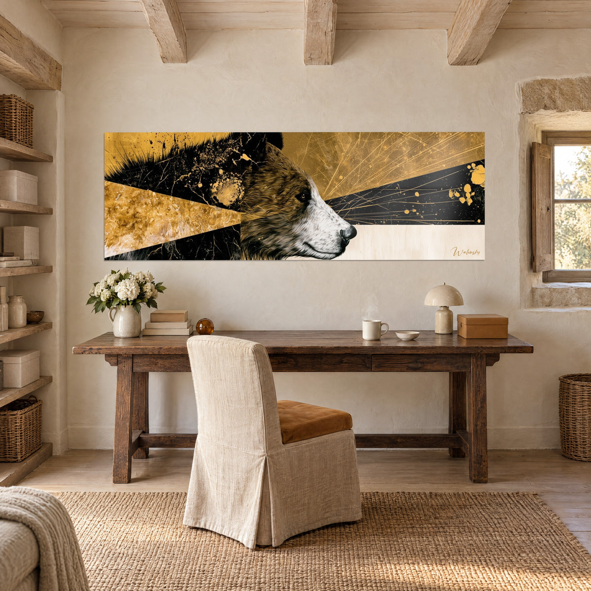 Tableau tête d'ours brun et blanc, éclats d'or sur fond noir, accroché au-dessus d'un bureau en bois dans une maison de pierre