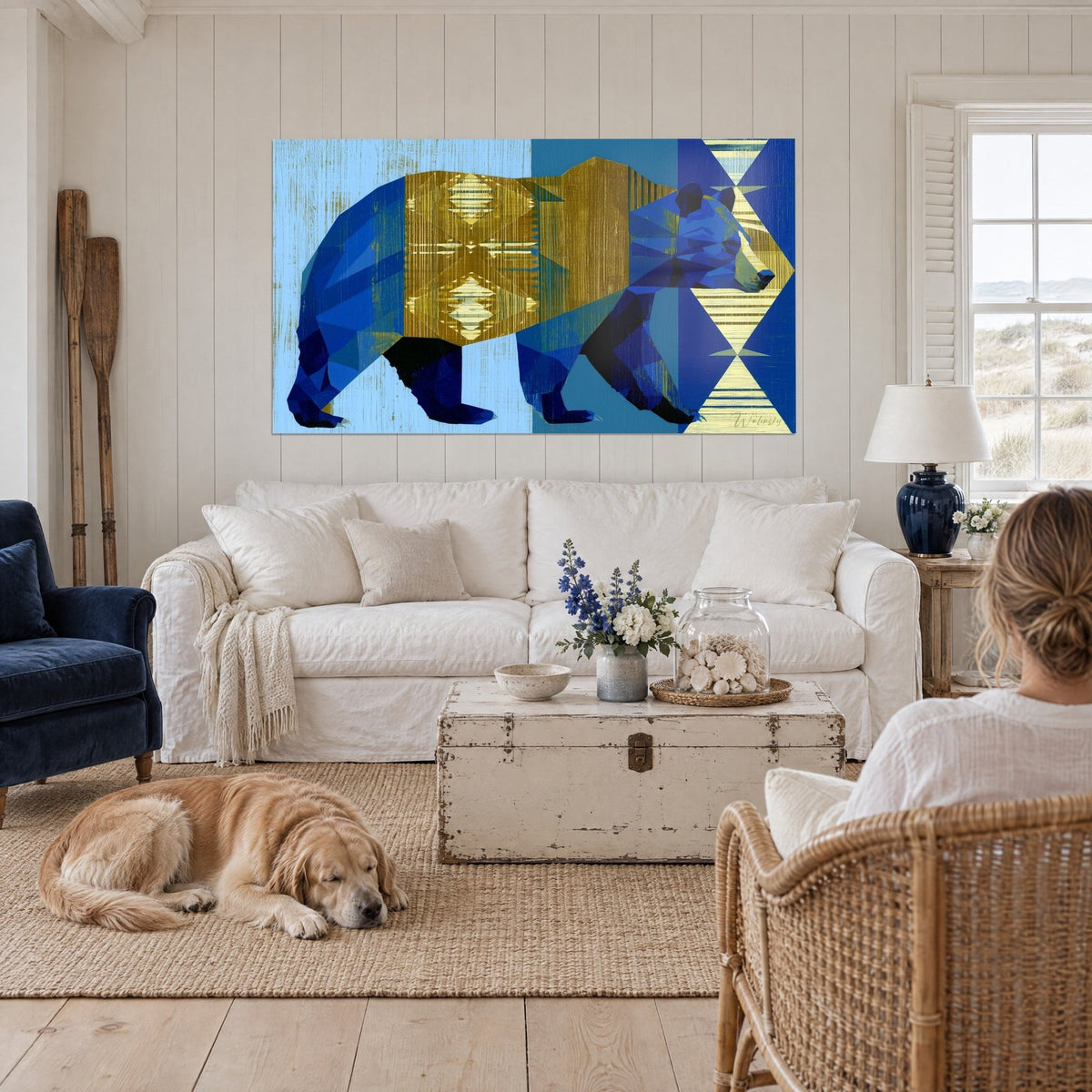 Gemälde Bär stilisiert in marineblauen Facetten auf goldenem Rautenrücken, nach rechts schreitend, über einem Sofa in einem hellen Wohnzimmer