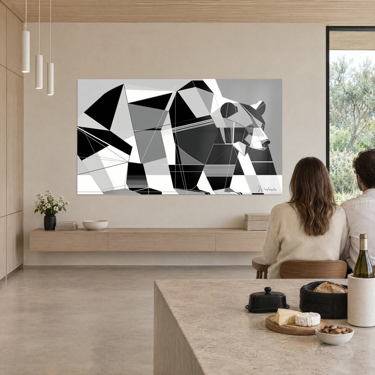 Quadro di un grizzly in piani geometrici neri e grigio perla, una coppia di spalle seduta sull'isola della cucina, parete beige di una casa d'architetto