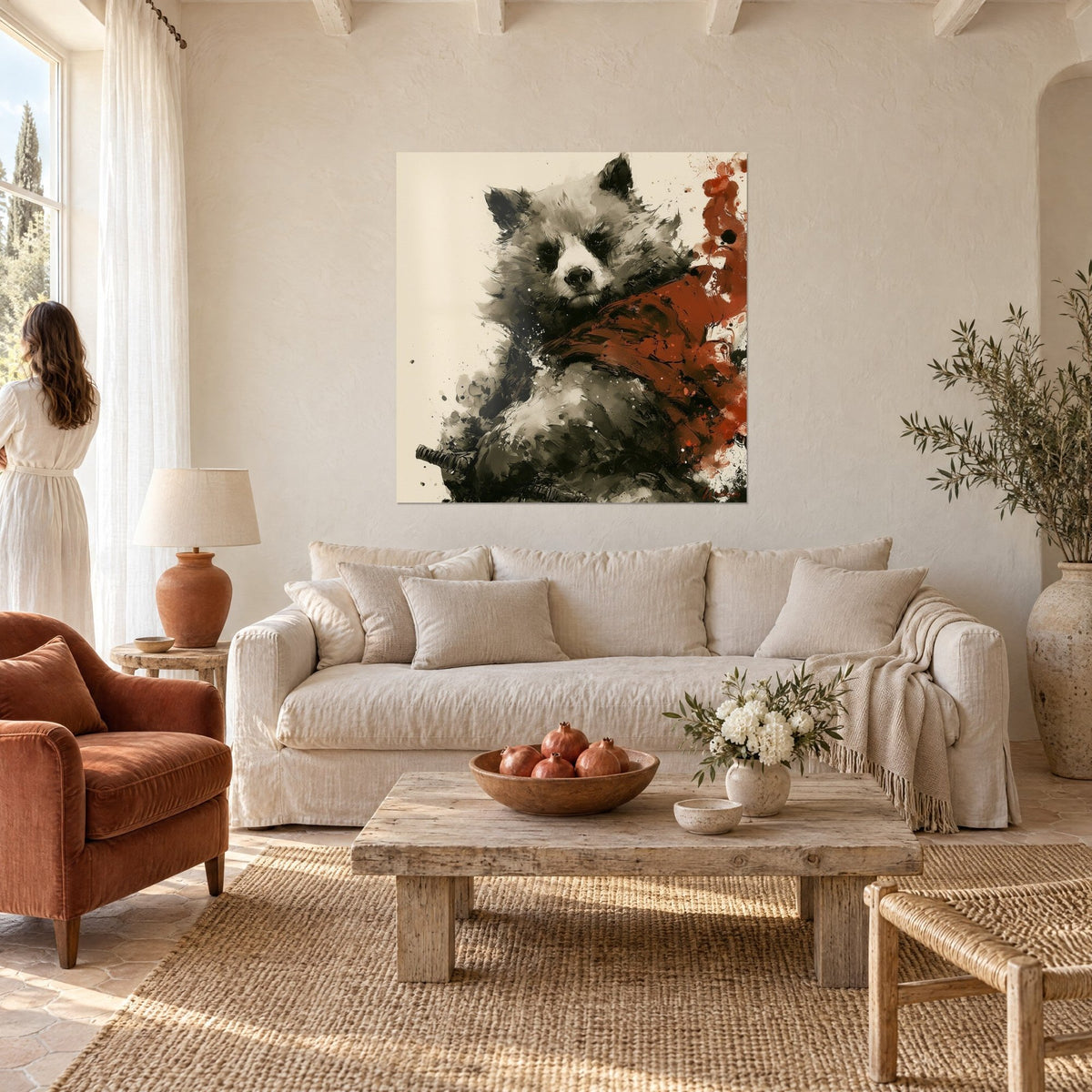 Gemälde Brauner Bär mit weißer Schnauze, ziegelrote Umhang, cremefarbener Hintergrund, eine Frau von hinten über einem Sofa in einem hellen Wohnzimmer