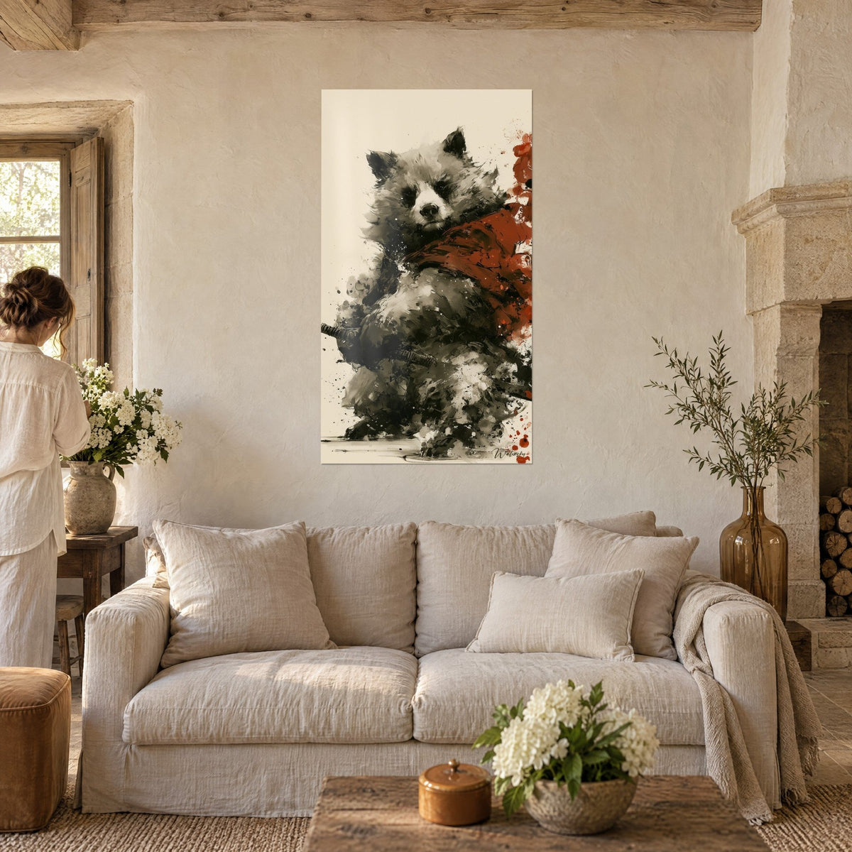 Wall art brown bear in black and red ink wash, sword at its side, bright red scarf, above a sofa in a bright living room