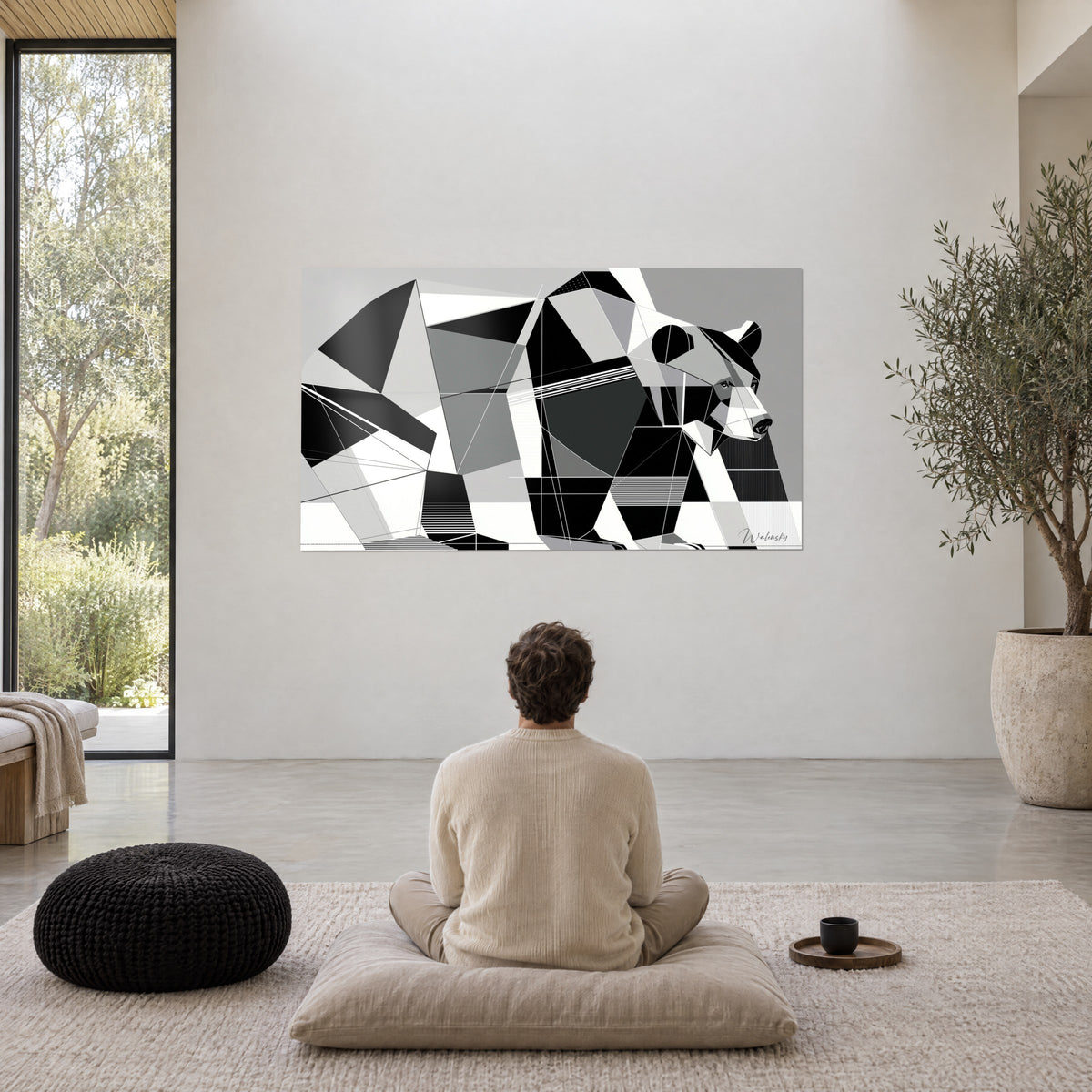 Quadro di una bestia frammentata in nero, bianco e grigio medio, un uomo di spalle seduto a gambe incrociate su un cuscino, ampio soggiorno aperto sugli alberi