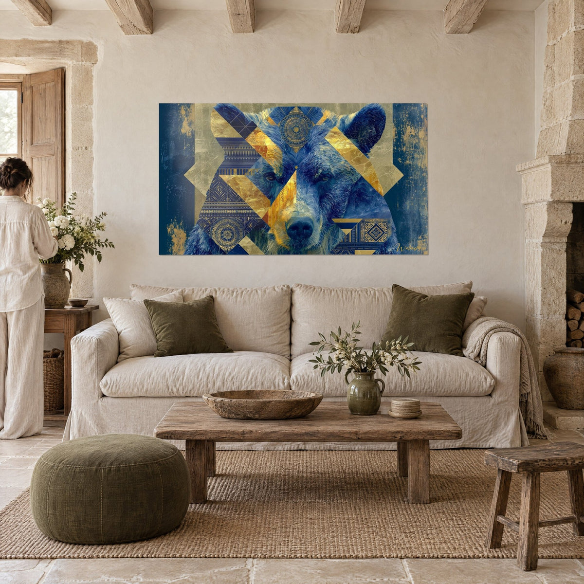 Wall art navy blue bear with gold leaf triangles and geometric friezes, two people seen from behind, above a sofa in a bright living room