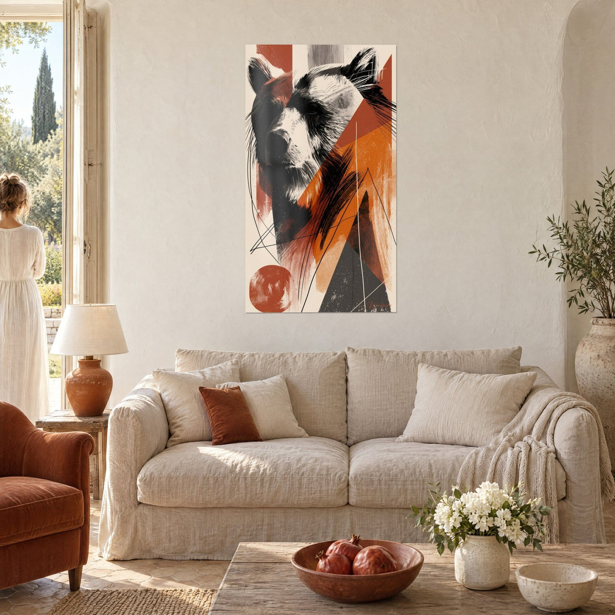 Wall art sketched brown bear, black and white muzzle, terracotta and orange triangles, two people seen from behind above a sofa in a bright living room