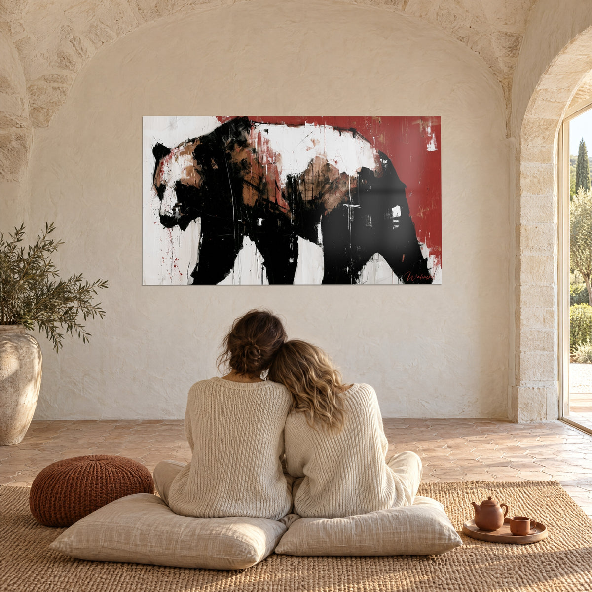 Wall art she-bear with a black back and white head, red splinters and drips, in a Provençal living room with a stone vaulted ceiling