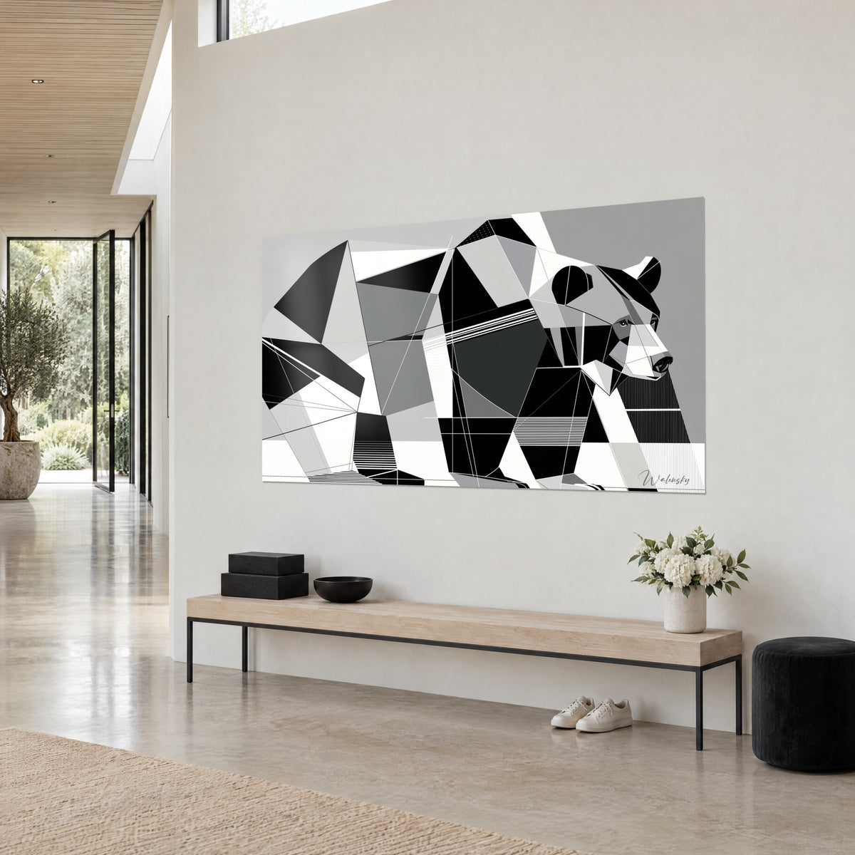 Quadro di un orso in triangoli antracite e avorio su sfondo grigio chiaro, visto di tre quarti, appeso sopra una panca di legno in una casa d'architetto
