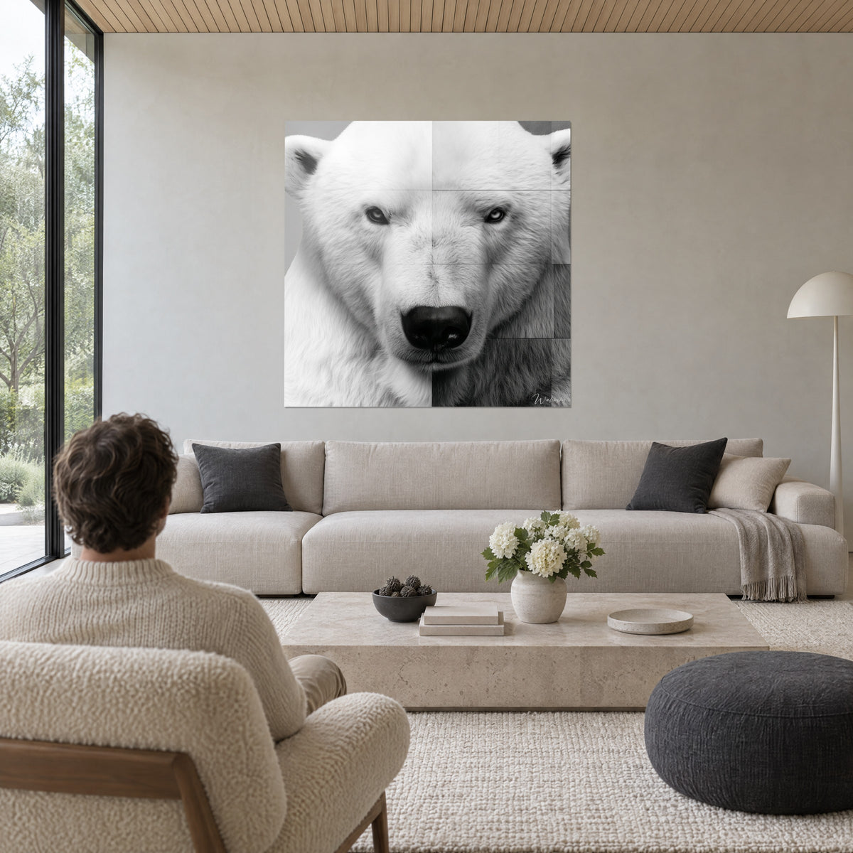 Quadro orso polare dal muso nero e pelliccia bianca brinata, sguardo grigio acciaio, sopra un divano in un soggiorno luminoso