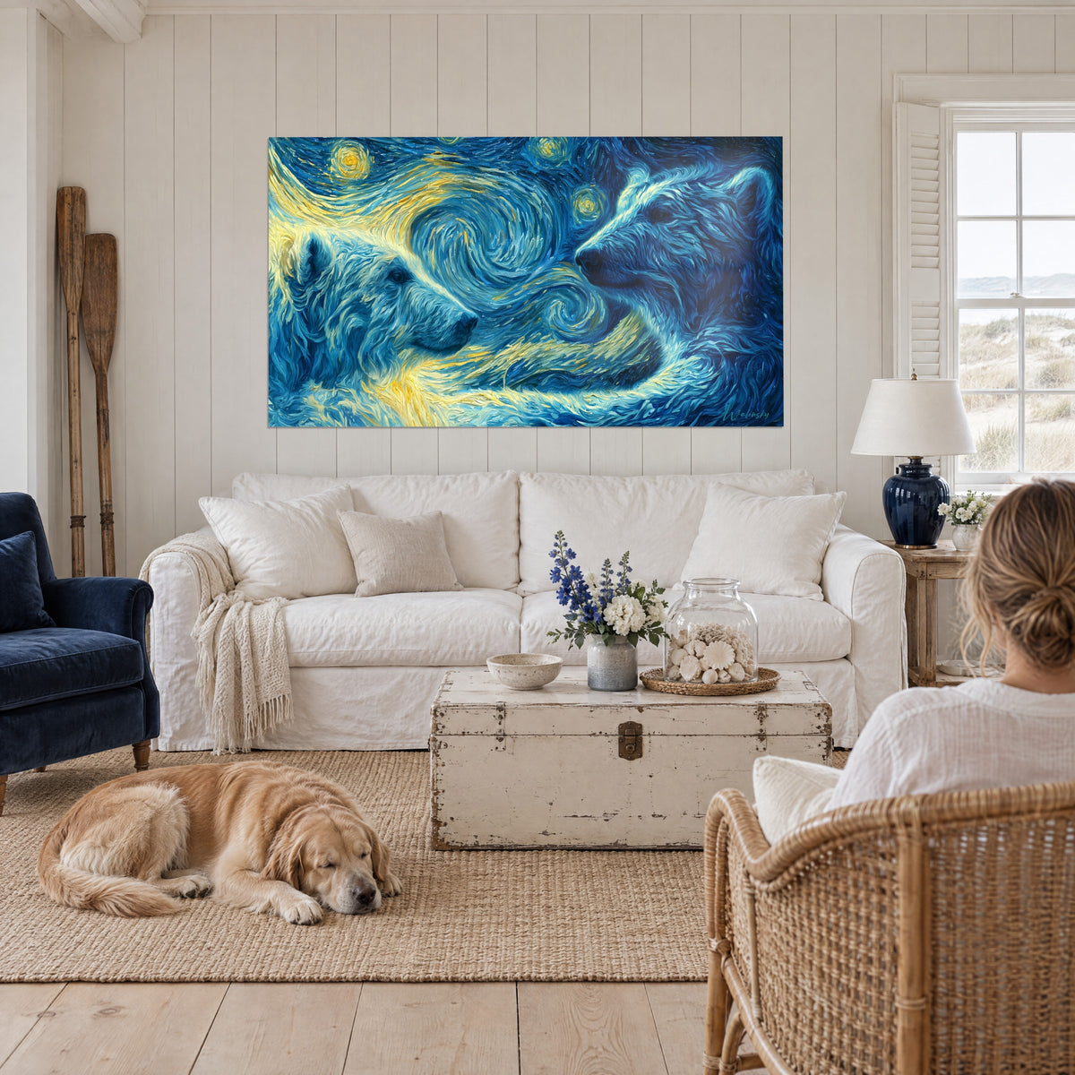 Wall art of two white polar bears under a starry blue and gold sky, mother and cub seen from behind, above a sofa in a bright living room