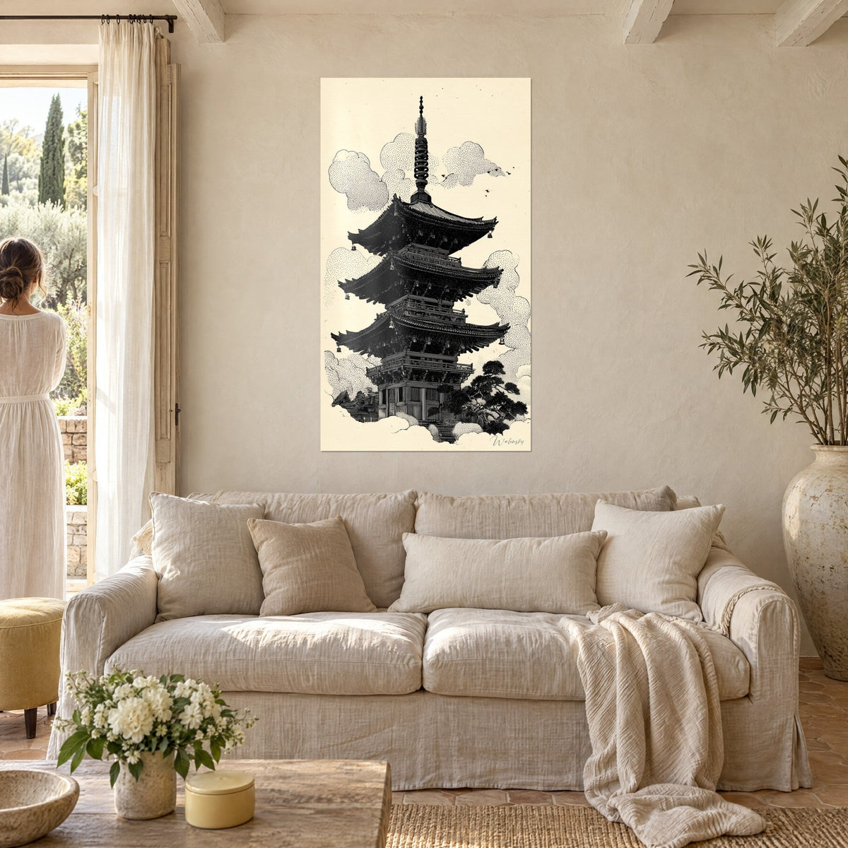Tableau pagode à cinq toits noirs sur fond crème, nuages pointillés, femme de dos, au-dessus d'un canapé dans un salon lumineux