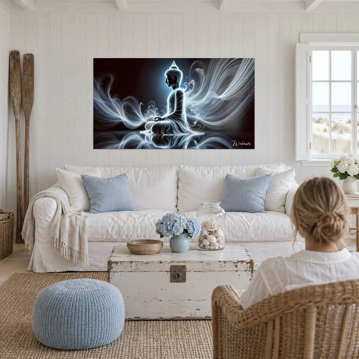 Wall art meditating Buddha in white light filaments on a black background, above a sofa in a bright living room
