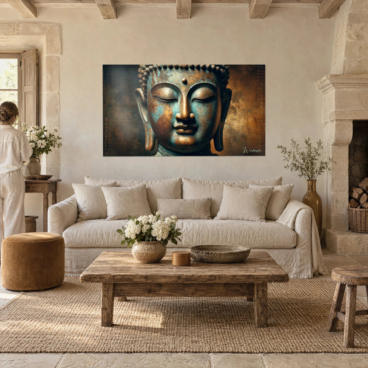 Tableau visage de Bouddha aux paupières closes, patine turquoise et cuivre, personne de dos, au-dessus d'un canapé dans un salon lumineux