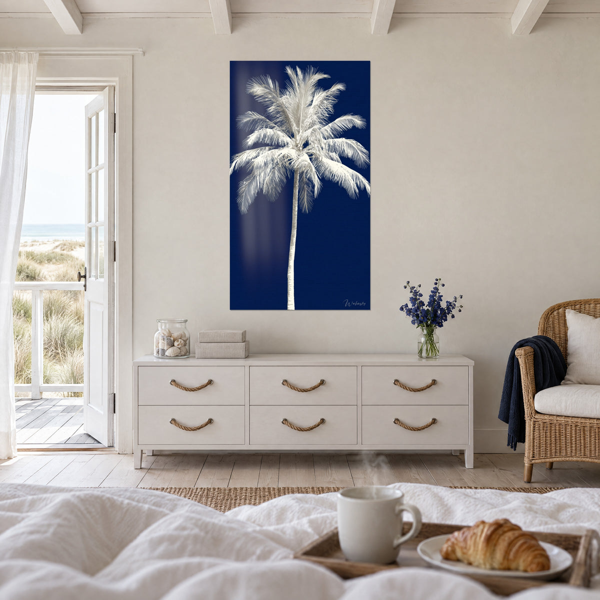 Tableau silhouette de palmier blanc sur aplat bleu marine, plumes dentelées, au-dessus d'un lit dans une chambre claire