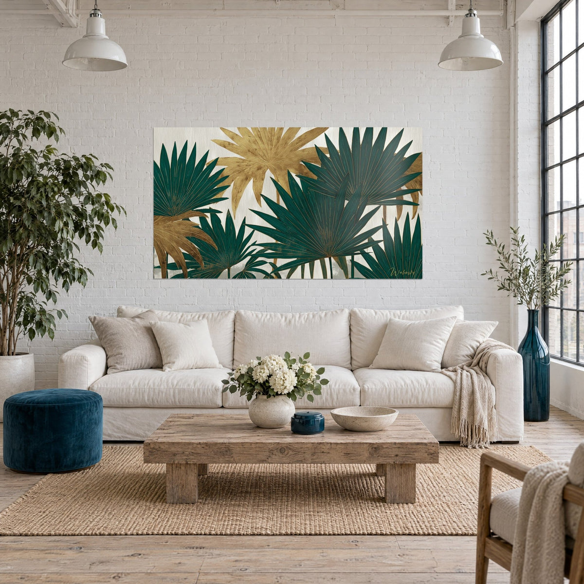 Wall art with emerald and gold fan palm leaves on a cream background, above a sofa in a bright living room