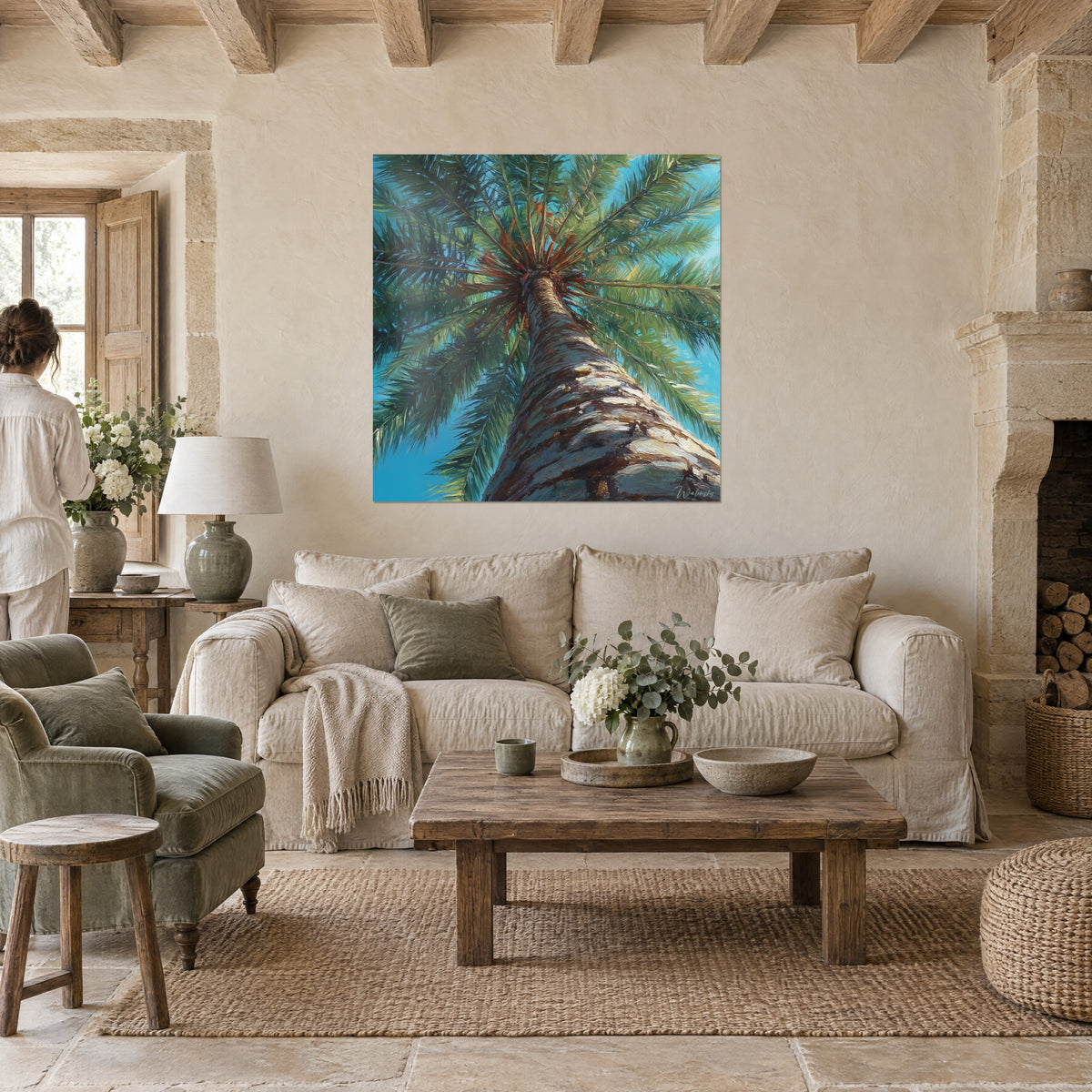 Wall art palm tree seen from below, scaly brown trunk and green fronds against a turquoise sky, above a sofa in a bright living room
