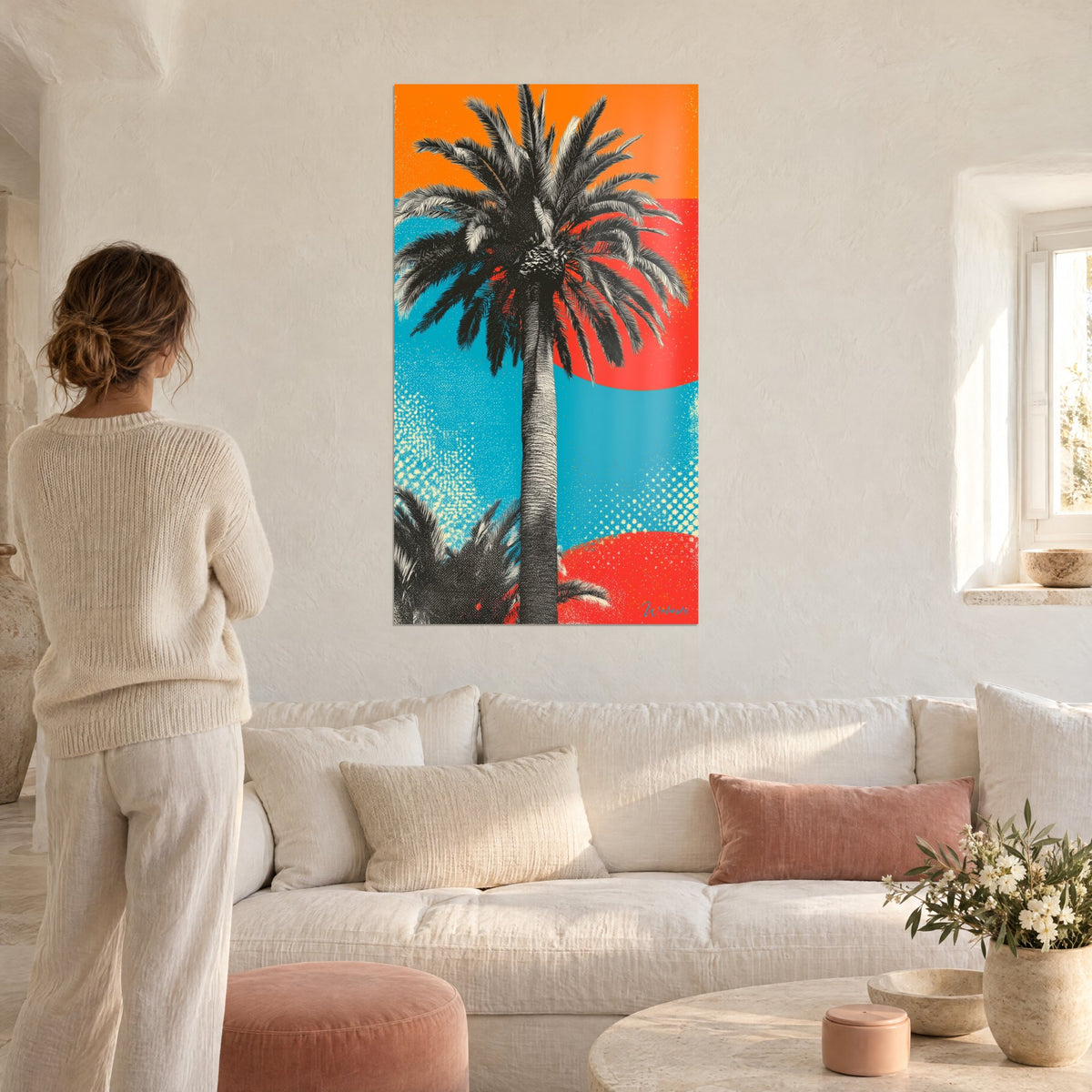 Wall art engraved palm tree in black and cream on orange and turquoise blue background, red sun, above a sofa in a bright living room