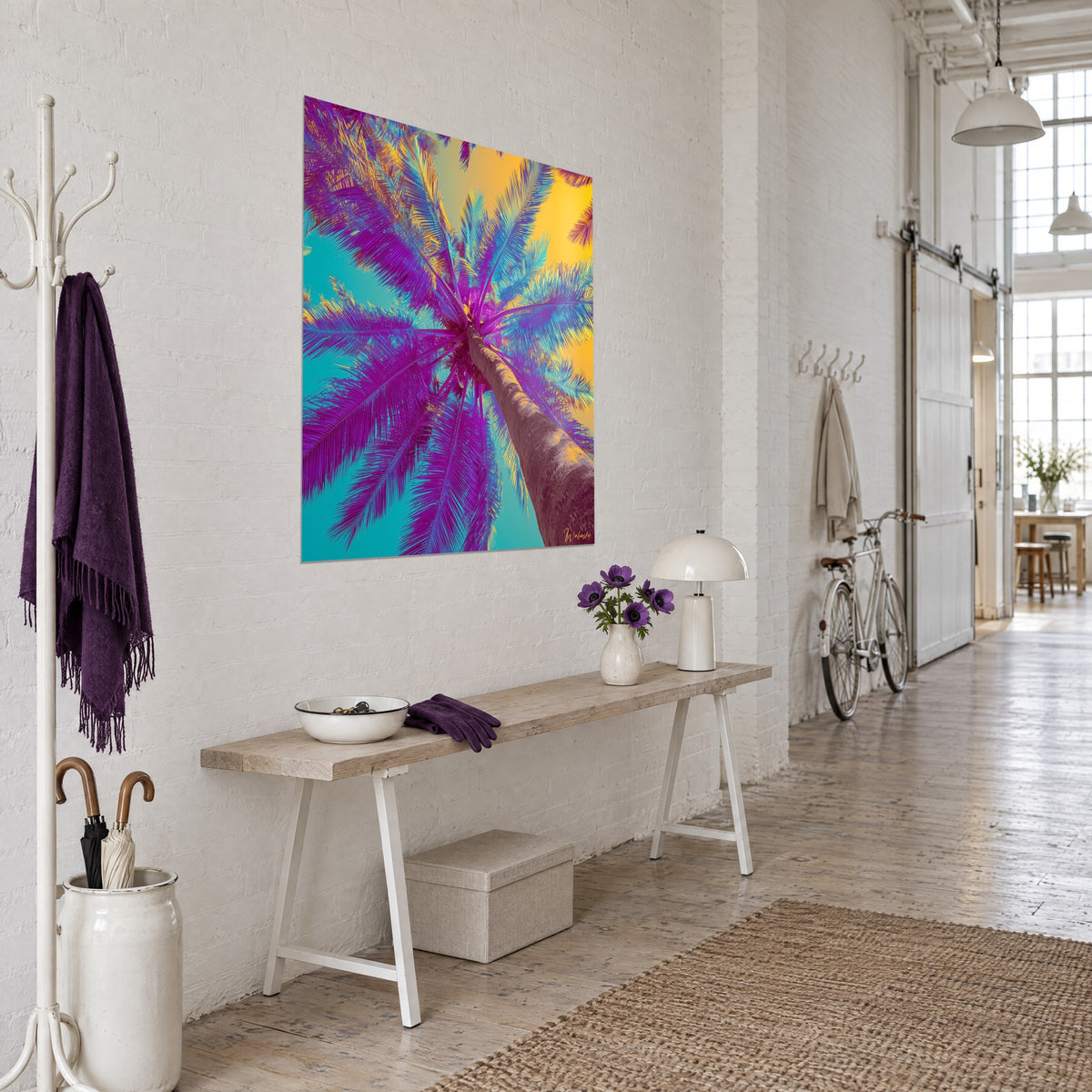 Wall art of a coconut palm in low-angle view, peeled brown trunk and violet fronds on a yellow background, artist loft in three-quarter view