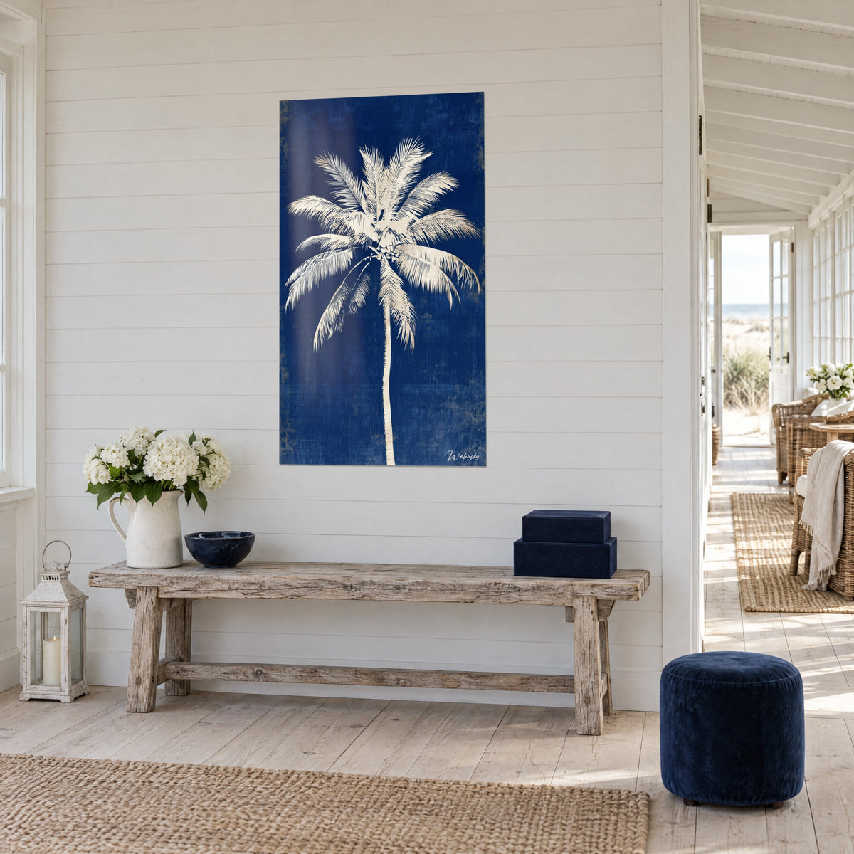 Wall art cream coconut palm standing out on a weathered midnight blue, above a console in blond wood and white peonies