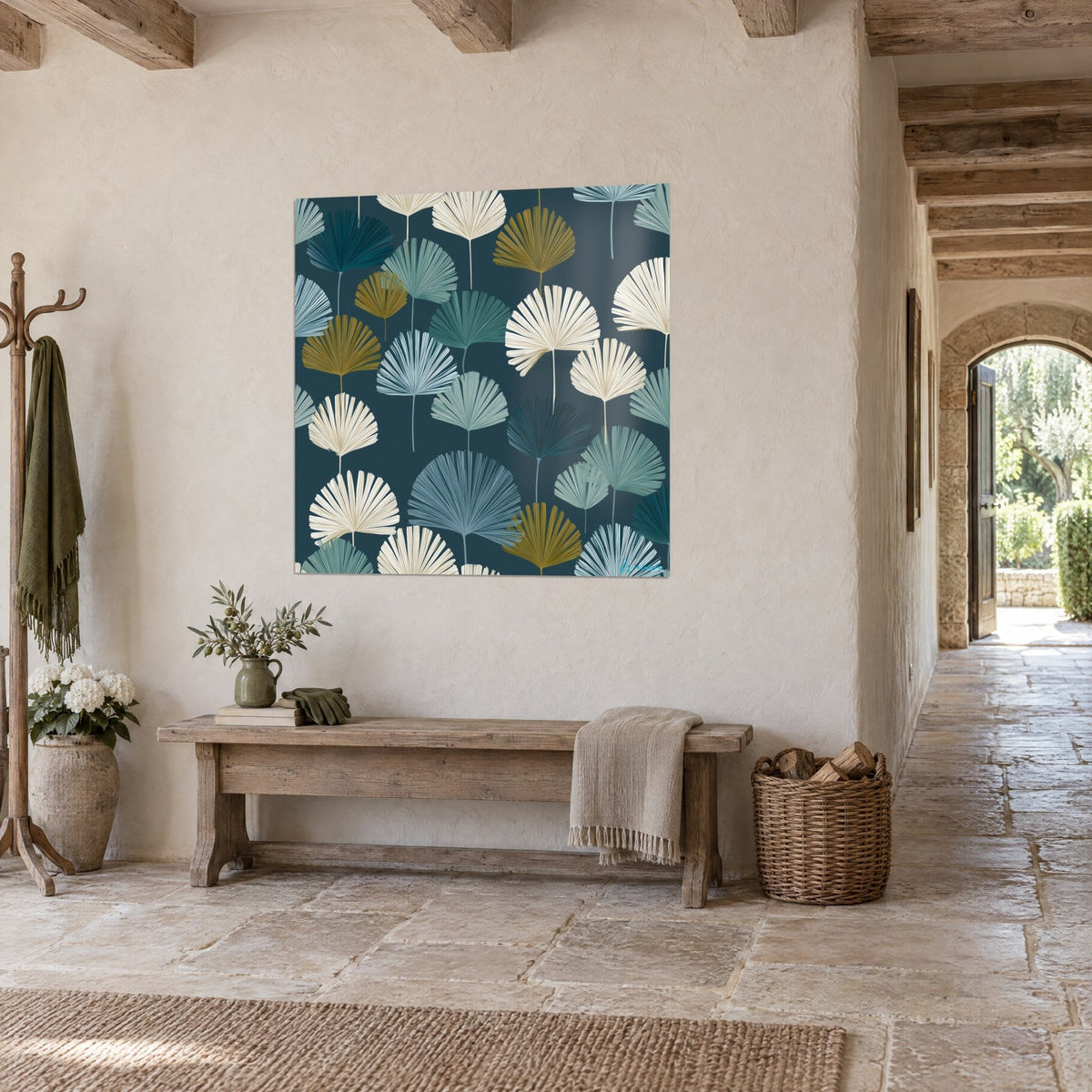 Wall art with golden and cream palm fronds on a navy background, hung on a limewashed wall, wooden bench and stone arch in the background