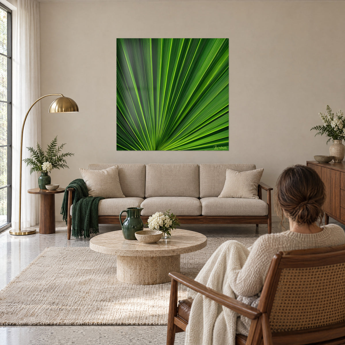 Schilderij van een waaierpalm met citroengele nerven op een smaragdgroene achtergrond, boven een bank in een lichte woonkamer gehangen