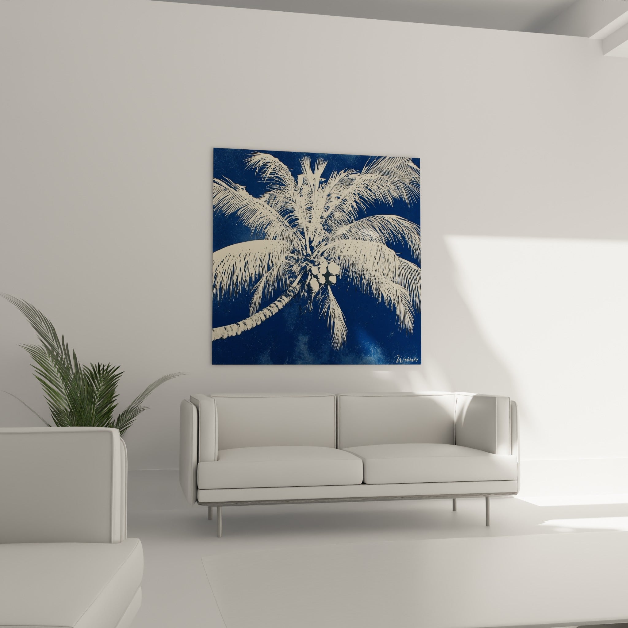 Tronc de palmier strié traverse la composition bleu marine et crème, disposé au-dessus d'un canapé dans un salon lumineux