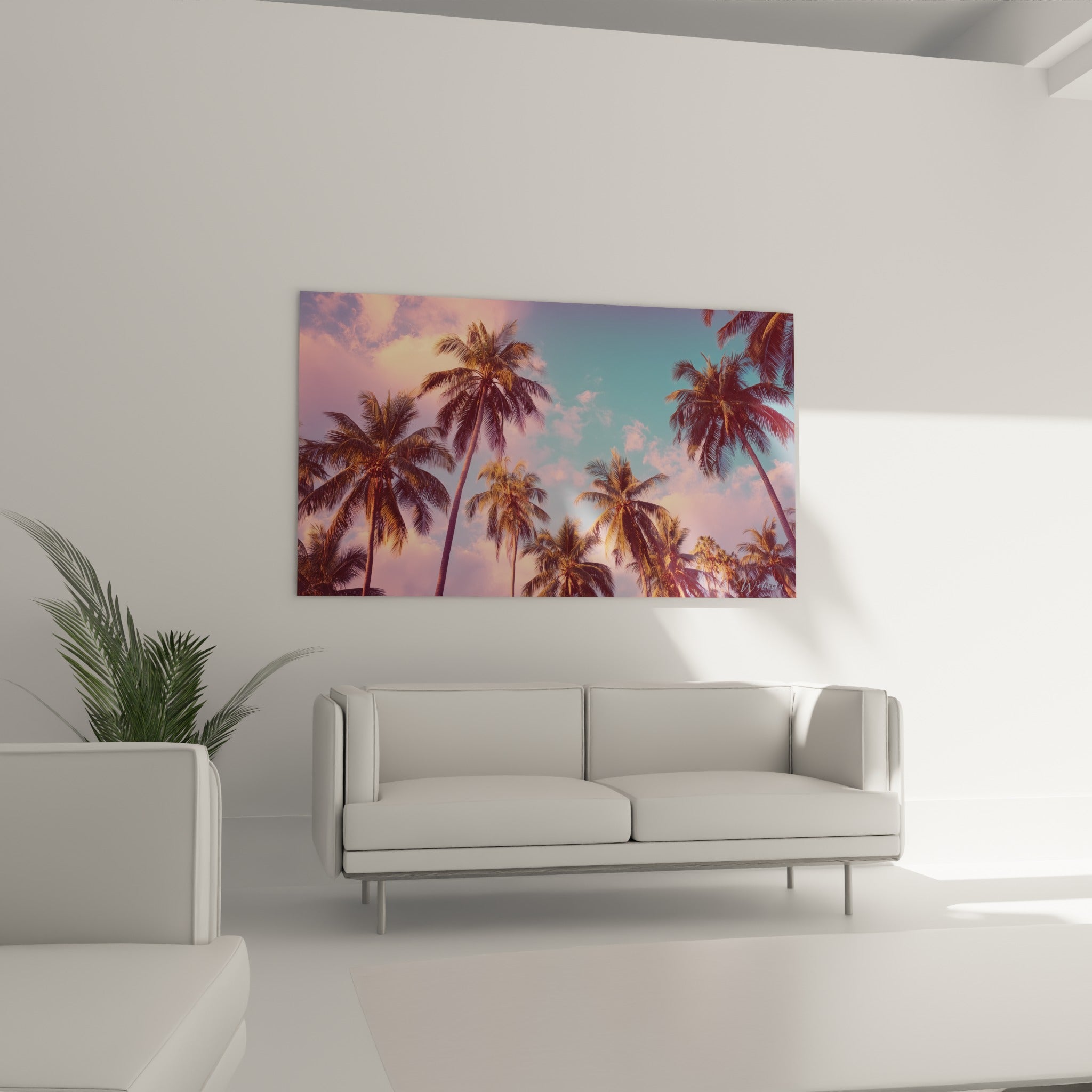 Feuillages de palmiers contrastant avec des nuages roses et un ciel turquoise au-dessus d'un canapé dans un salon lumineux