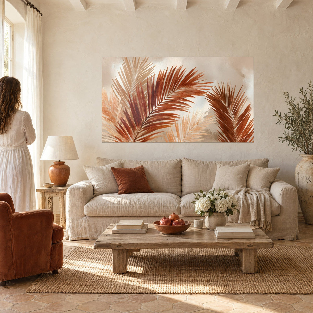 Gemälde mit Palmwedeln in Terrakotta und Beige an der weißen Wand eines provenzalischen Mas, Leinensofa darunter in einem hellen Wohnzimmer