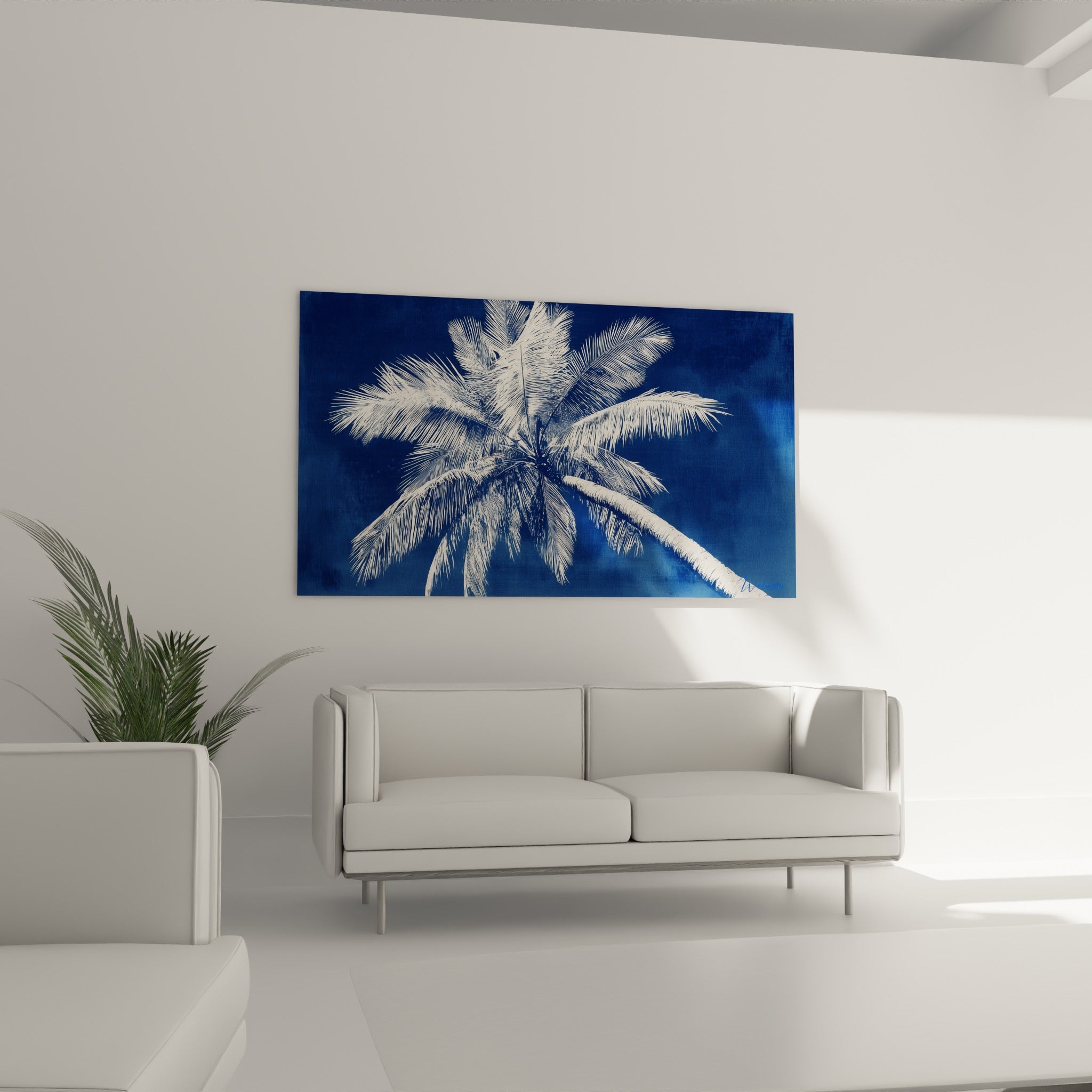Tronc courbé du palmier en camaïeu bleu et blanc, au-dessus d'un canapé dans un salon lumineux