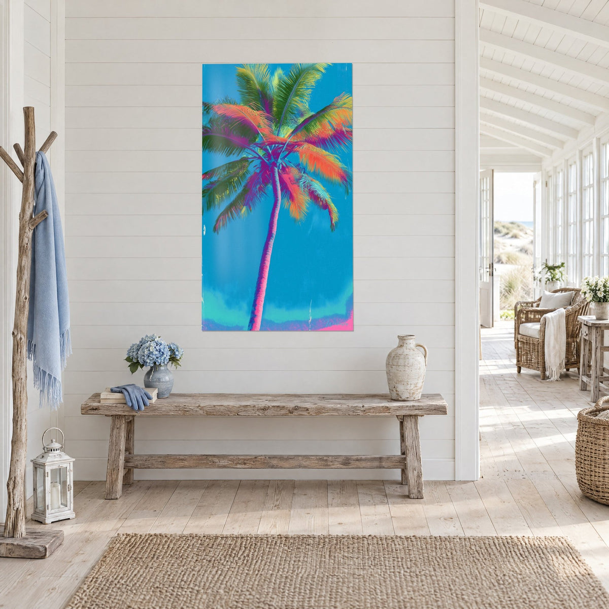 Quadro cocco vibrante, fogliame arancio e verde su sfondo blu, appeso sopra una panca in legno, casa sul mare