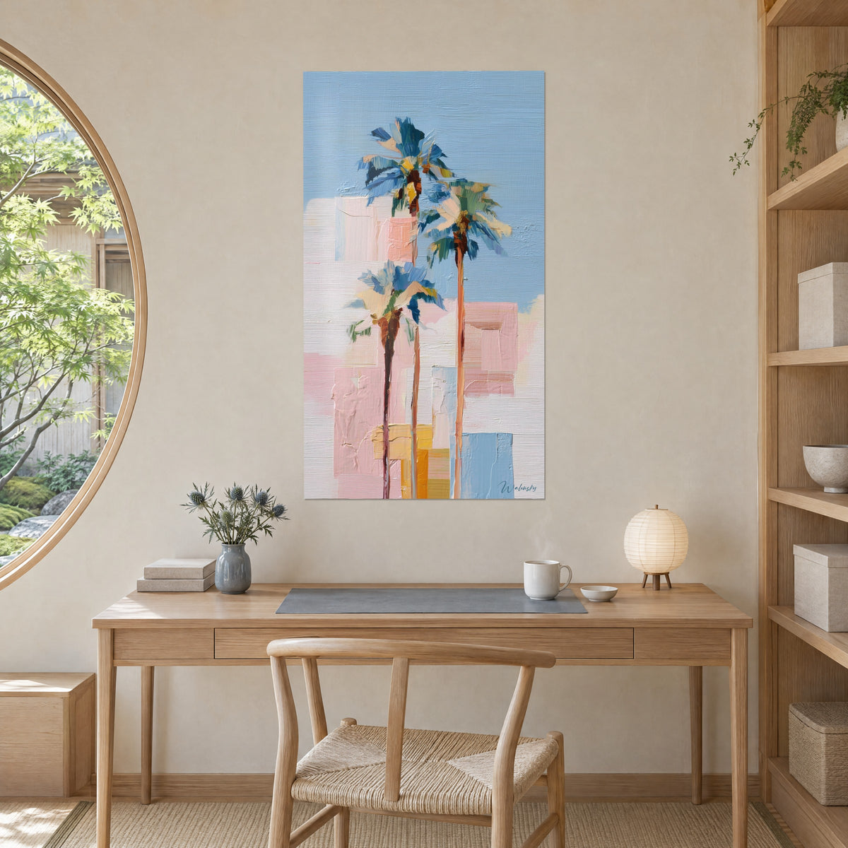 Quadro trittico vegetale di fronde blu su fondo rosa e crema, tratto verticale dei tronchi, appeso dietro una scrivania in legno chiaro