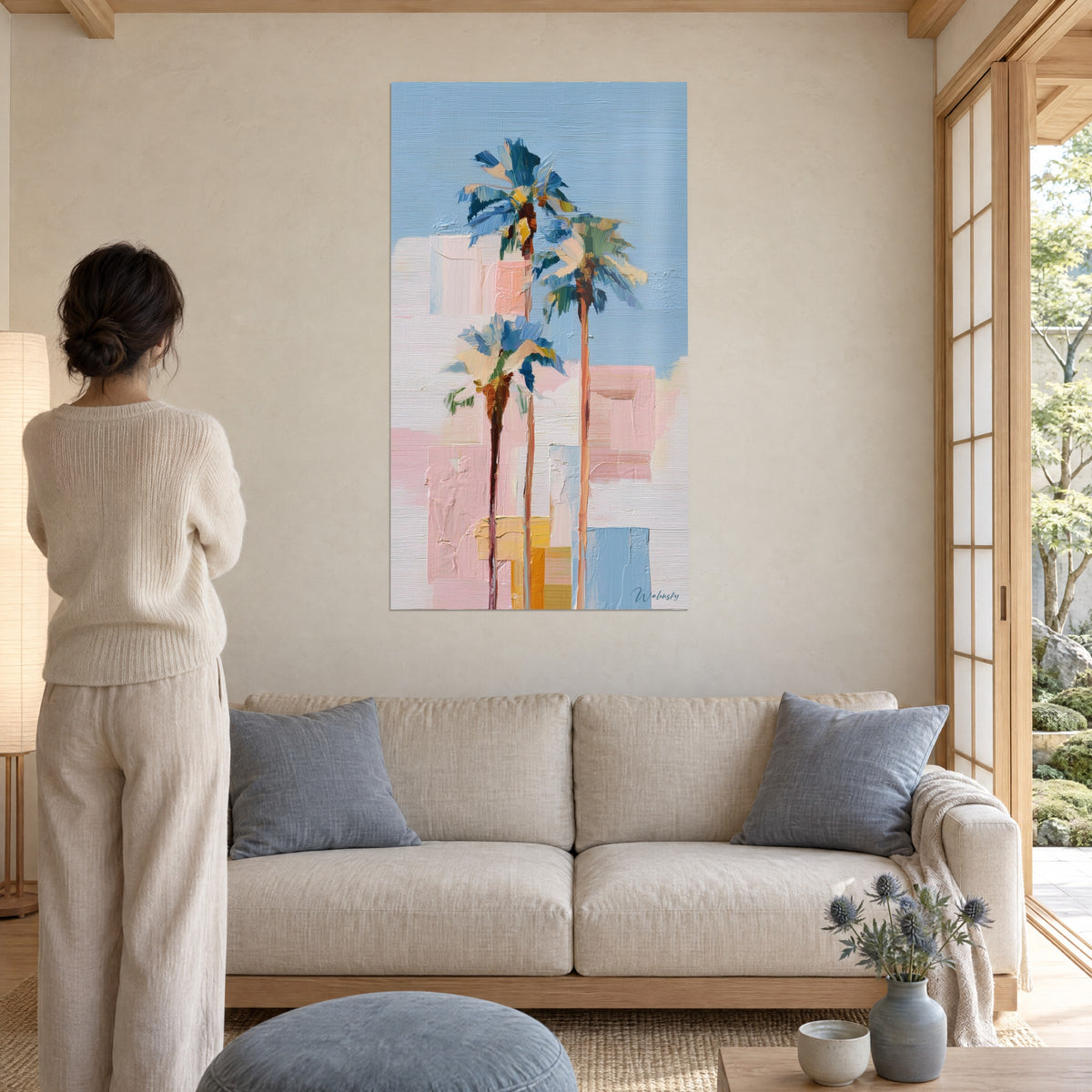 Quadro di palme slanciate con fronde blu cobalto e rosa cipria, impasto a spatola, sopra un divano in un soggiorno luminoso