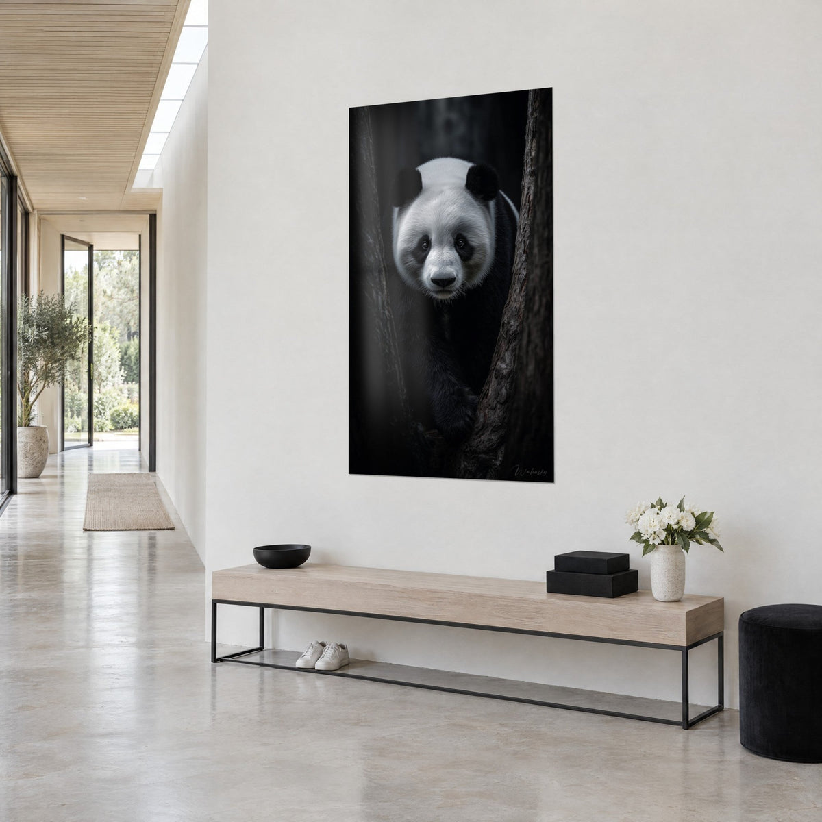 Quadro orso di bambù con maschera bianca e orecchie nere, appeso a parete bianca sopra una panca in legno chiaro, corridoio di casa d'architetto
