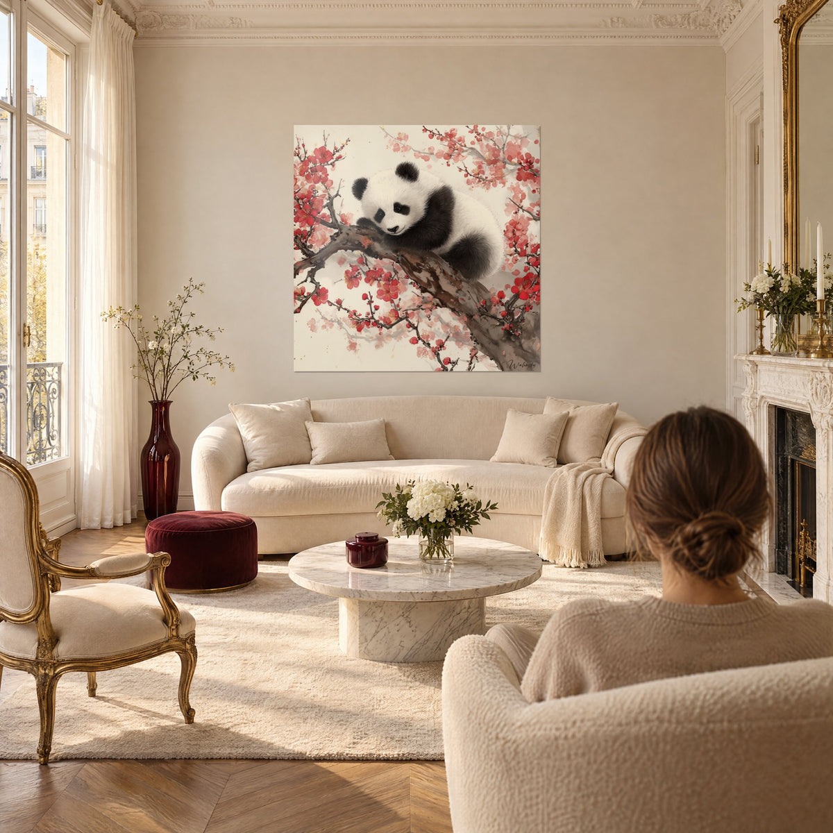 Gemälde Babypanda, zusammengerollt auf einem Ast, schwarz-weißes Fell, rote Blüten, über einem Sofa in einem hellen Wohnzimmer