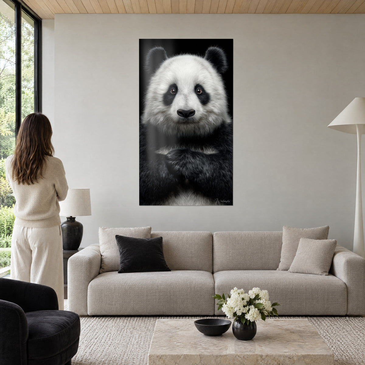 Πίνακας γιγαντιαίος panda με κρεμ-λευκή και μαύρη γούνα, με διπλωμένα τα πόδια στο στήθος, φόντο από μελάνι, πάνω από καναπέ σε φωτεινό σαλόνι