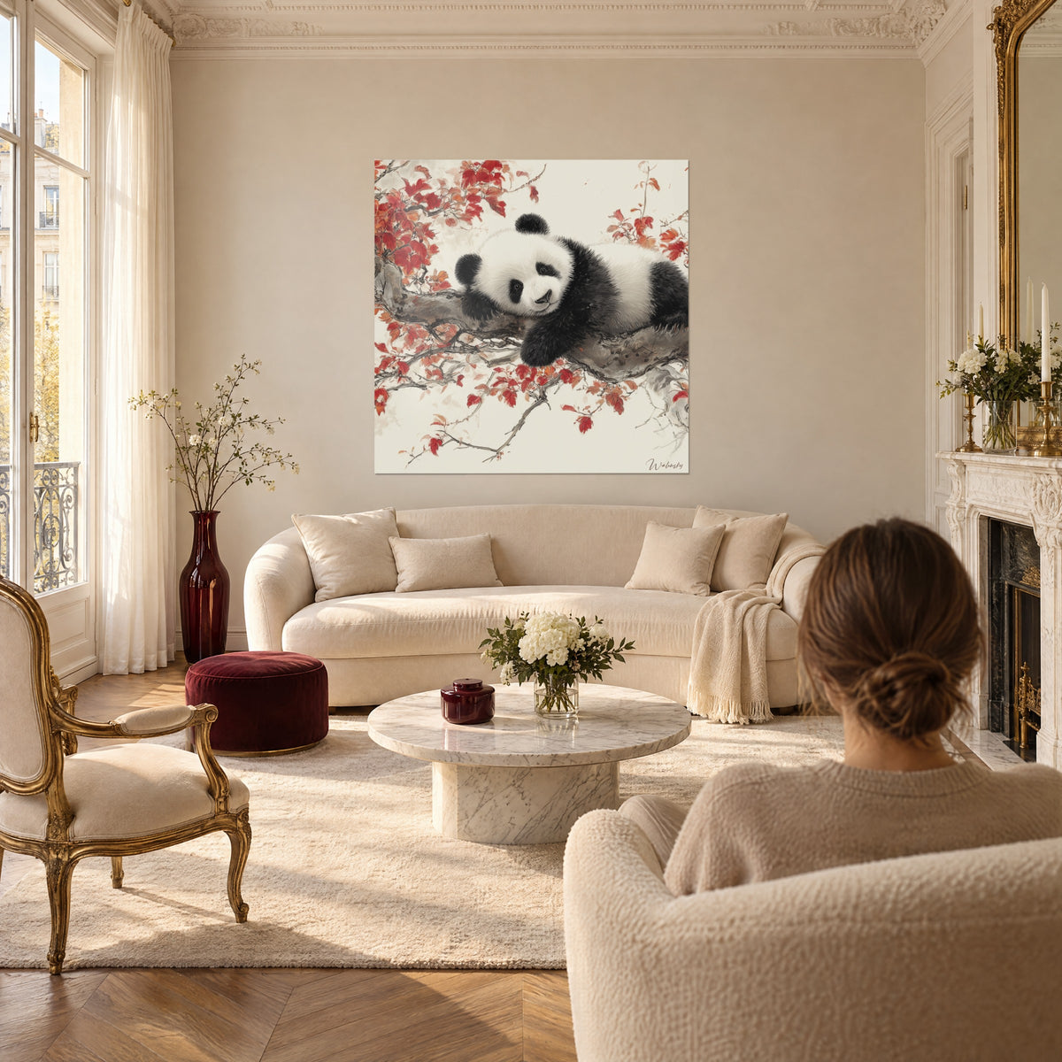 Gemälde eines riesigen Pandas, zusammengerollt auf einem Ast, rote und orangefarbene Blätter auf cremefarbenem Hintergrund, über einem Sofa in einem hellen Wohnzimmer