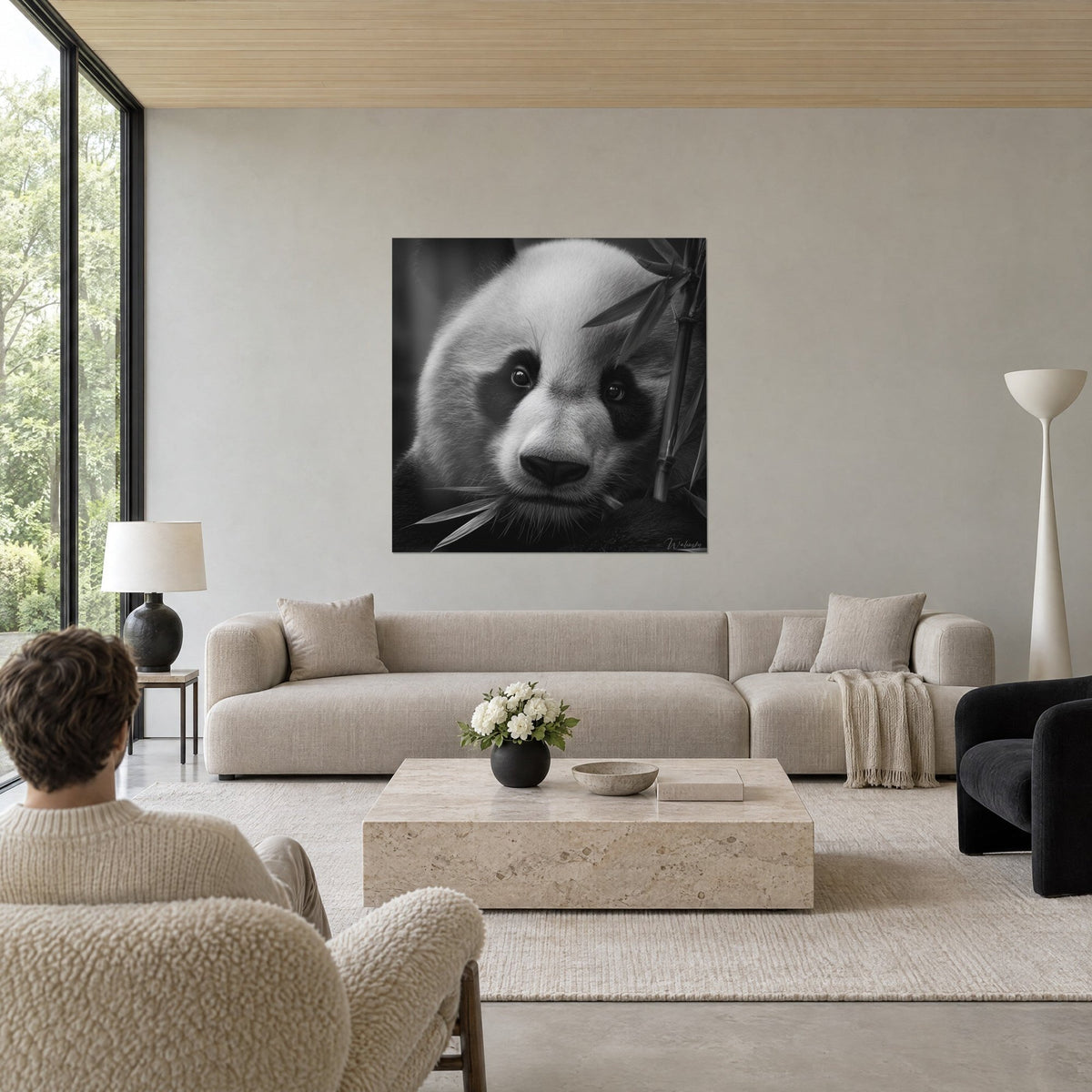 Wall art giant panda with ink-black eye patches and silvery bamboo, white fur and deep black, above a sofa in a bright living room