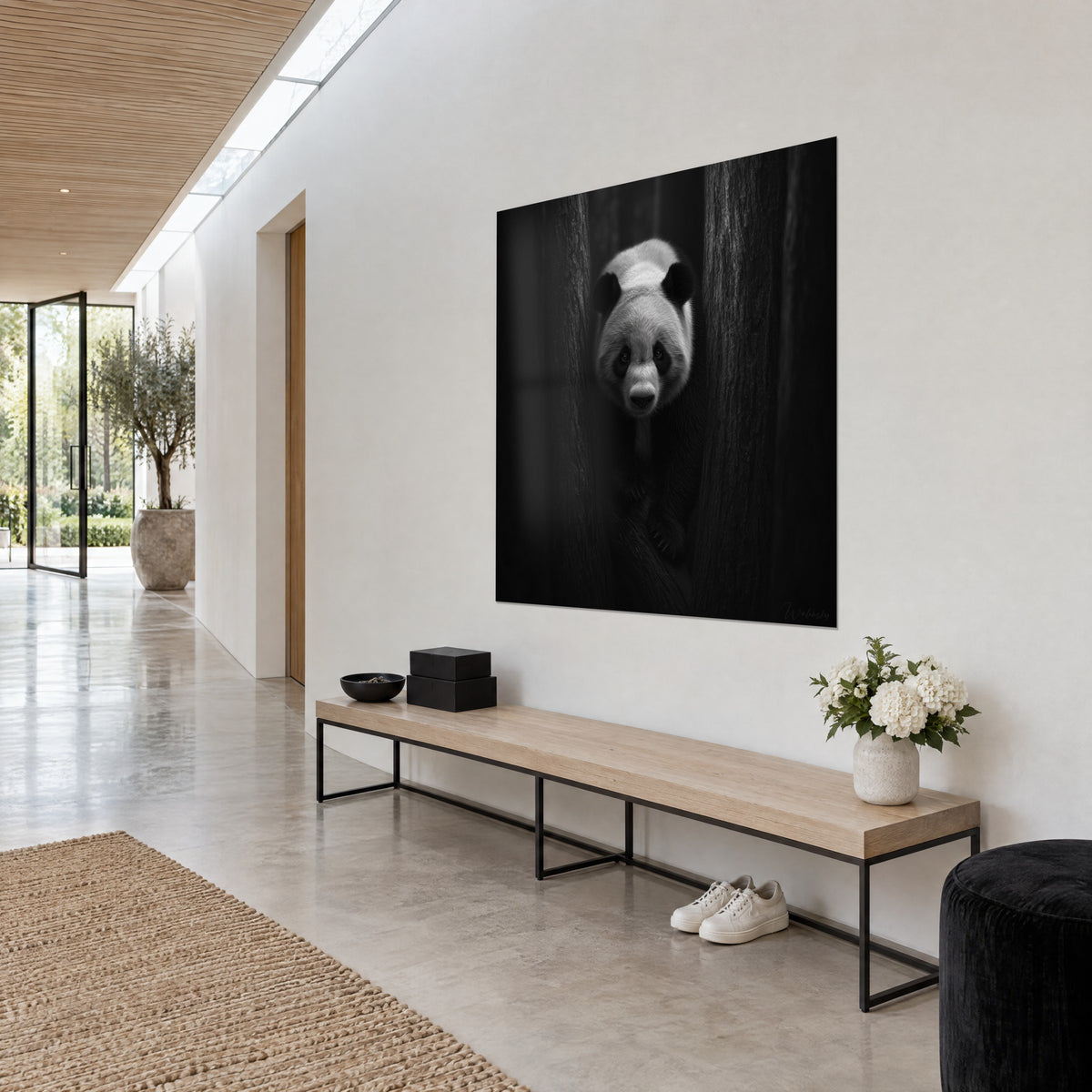 Cuadro oso de bambú con máscara facial oscura, pelaje marfil sobre fondo carbón, vista de tres cuartos en un pasillo de casa de arquitecto