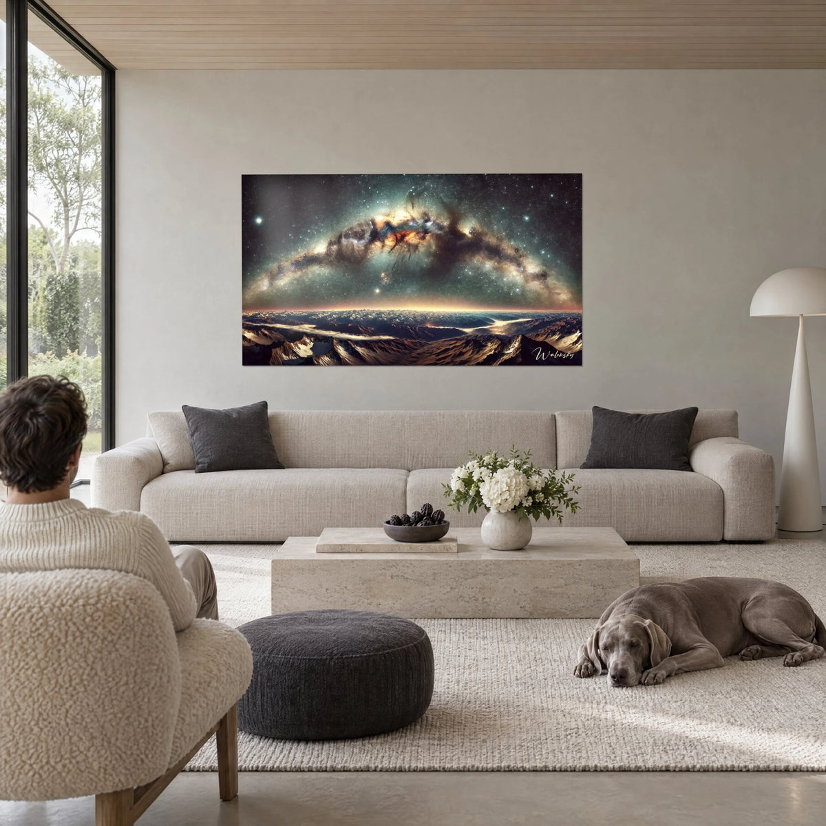 Cuadro bóveda de la Vía Láctea con nebulosas ocres y turquesas, picos nevados debajo, visto de espaldas, weimaraner tumbado, encima de un sofá en un salón luminoso