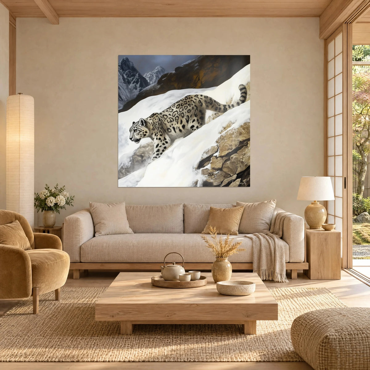 Gemälde Schneeleopard mit schwarzen Rosetten, der einen weißen Hang hinabsteigt, ockerfarbener Fels, über einem Sofa in einem hellen Wohnzimmer