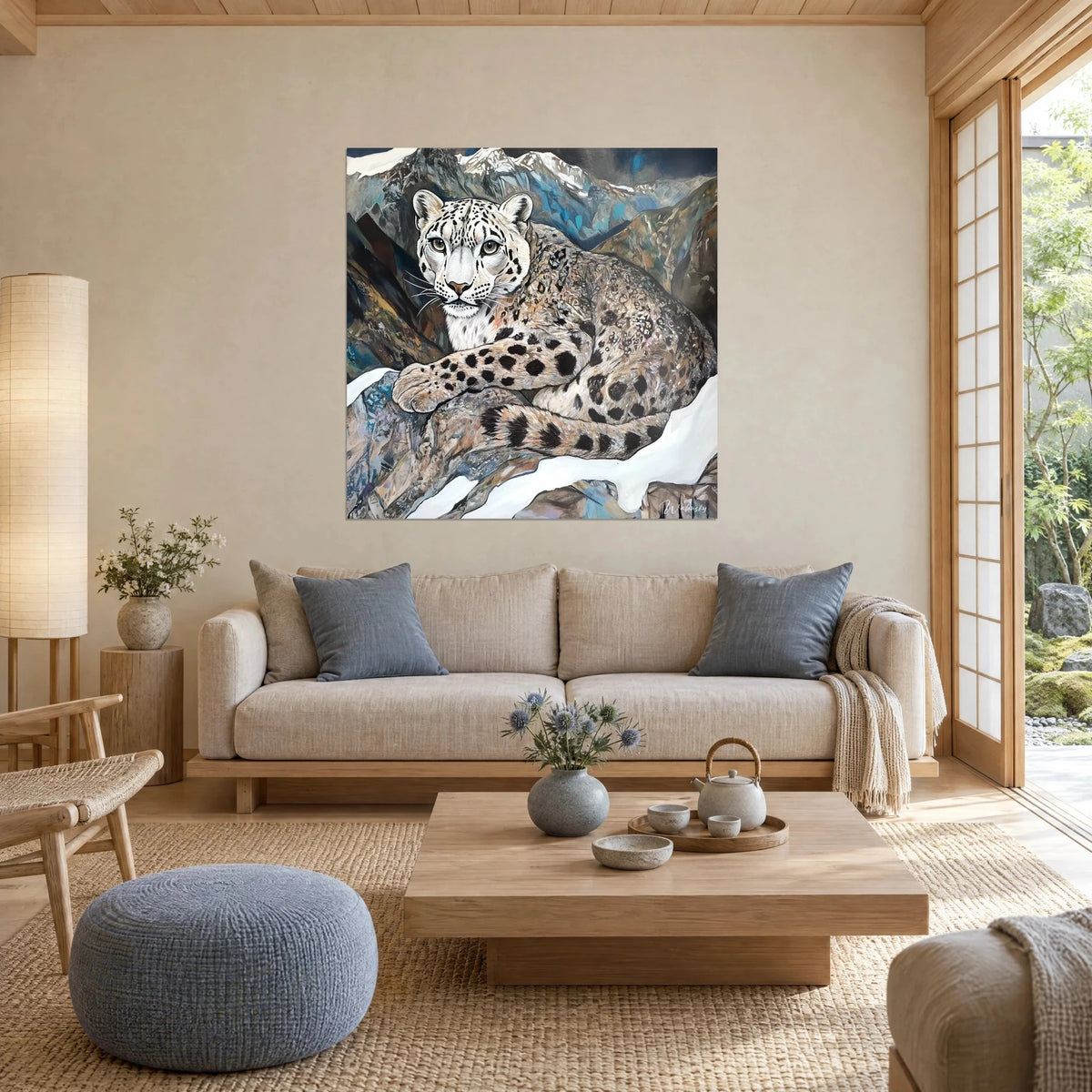 Wall art snow leopard with jade-green eyes, cream fur spotted with black, against bluish mountains, above a sofa in a bright living room