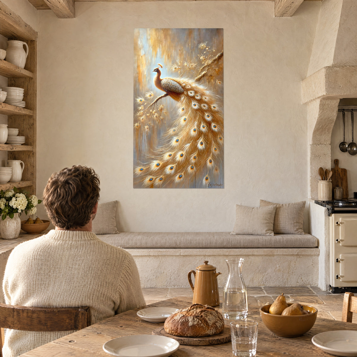Quadro pavone bianco sporco e oro pallido, lunga coda con occhi blu, su una parete in pietra intonacata di una cucina con tavolo in legno